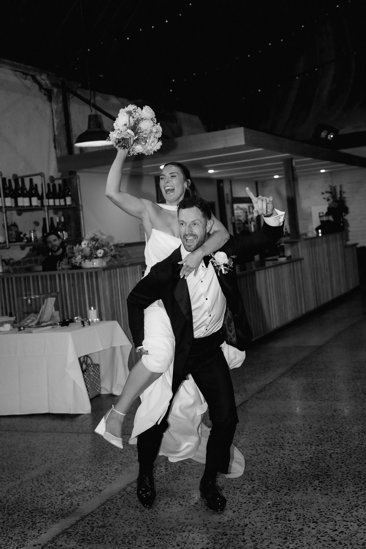 Black and white photos of a couple performing a dramatic dance dip sequence at a wedding reception.