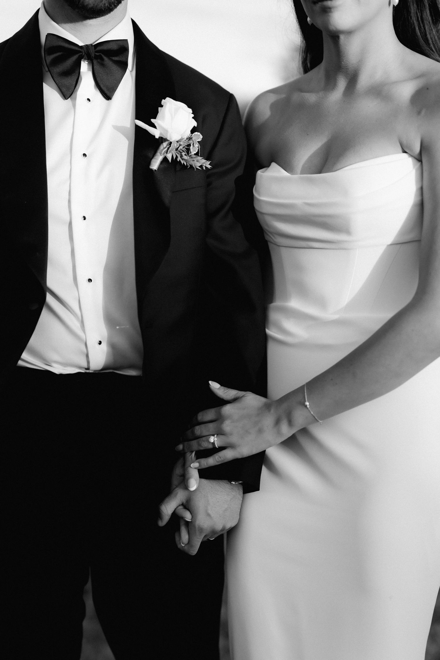 Black and white close-up shots of formal wedding attire showing tuxedo and dress details.