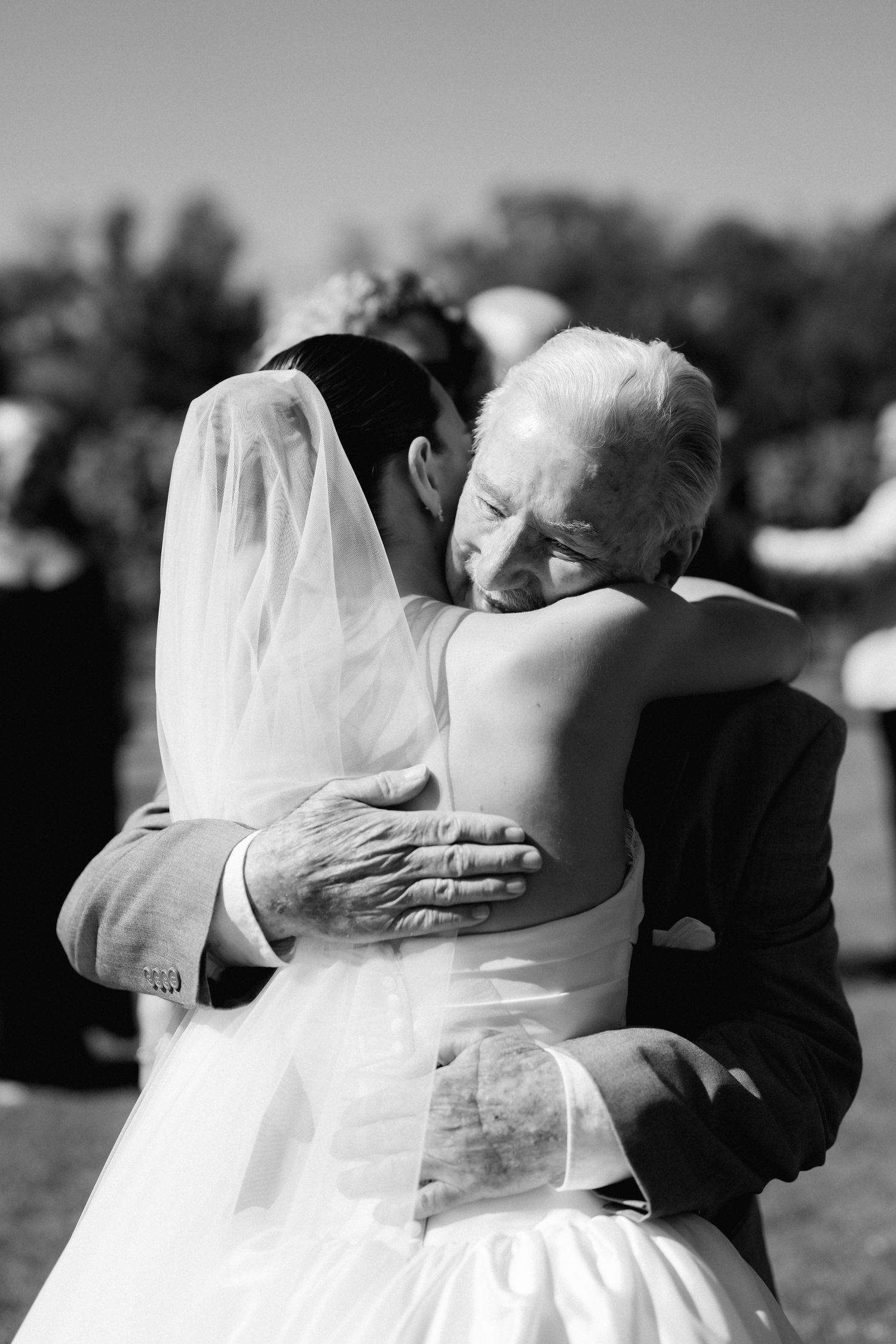 Black and white sequence of emotional wedding embraces outdoors.