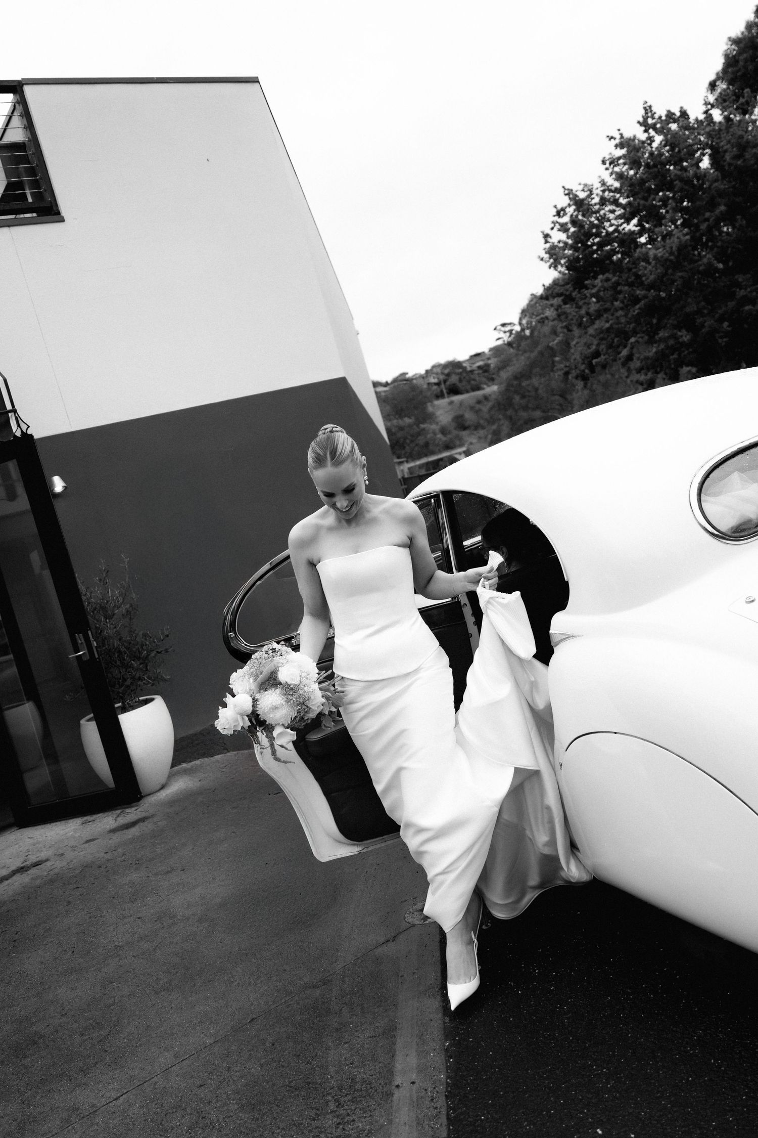 A person in a white wedding dress climbs into a small private aircraft on their special day.