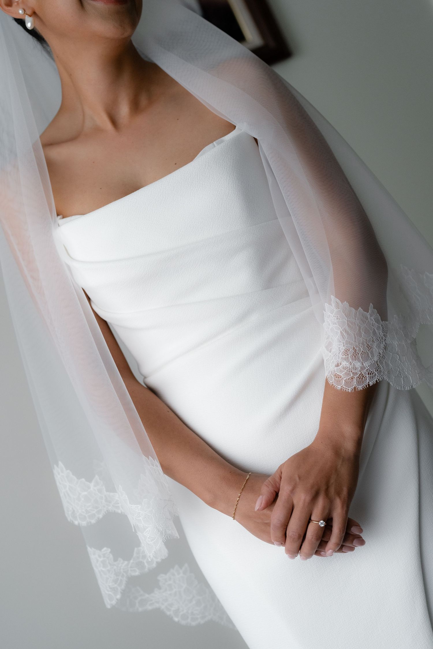 Detail shots of classic white wedding dress with lace veil and elegant styling.