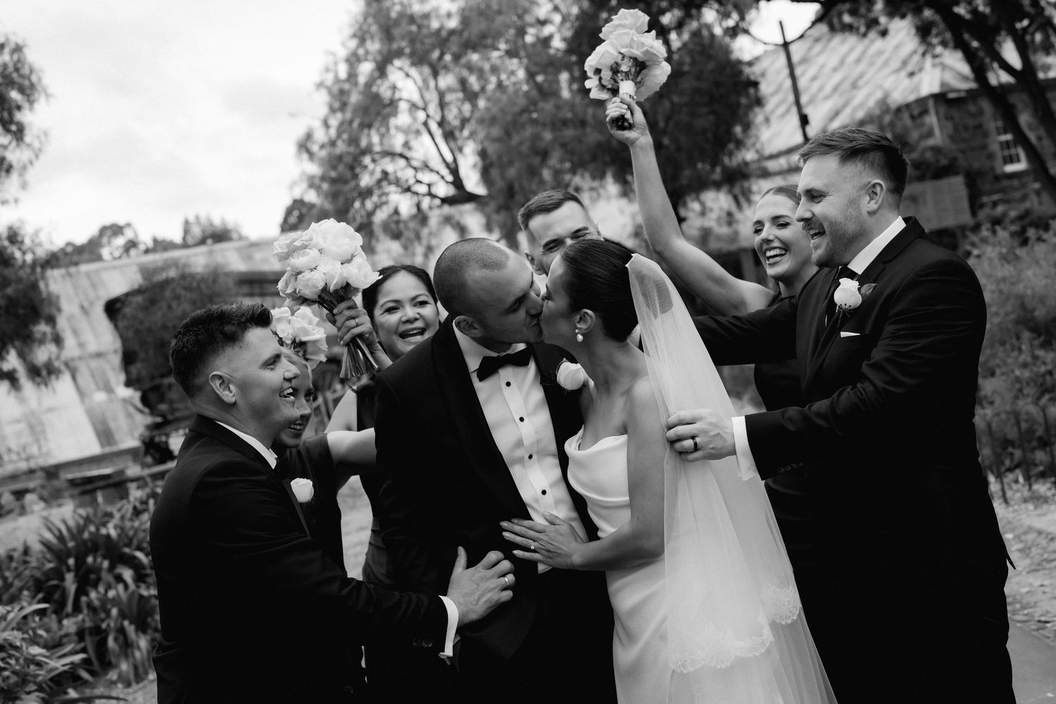A series of candid black and white wedding moments showing laughter and joy during the celebration.