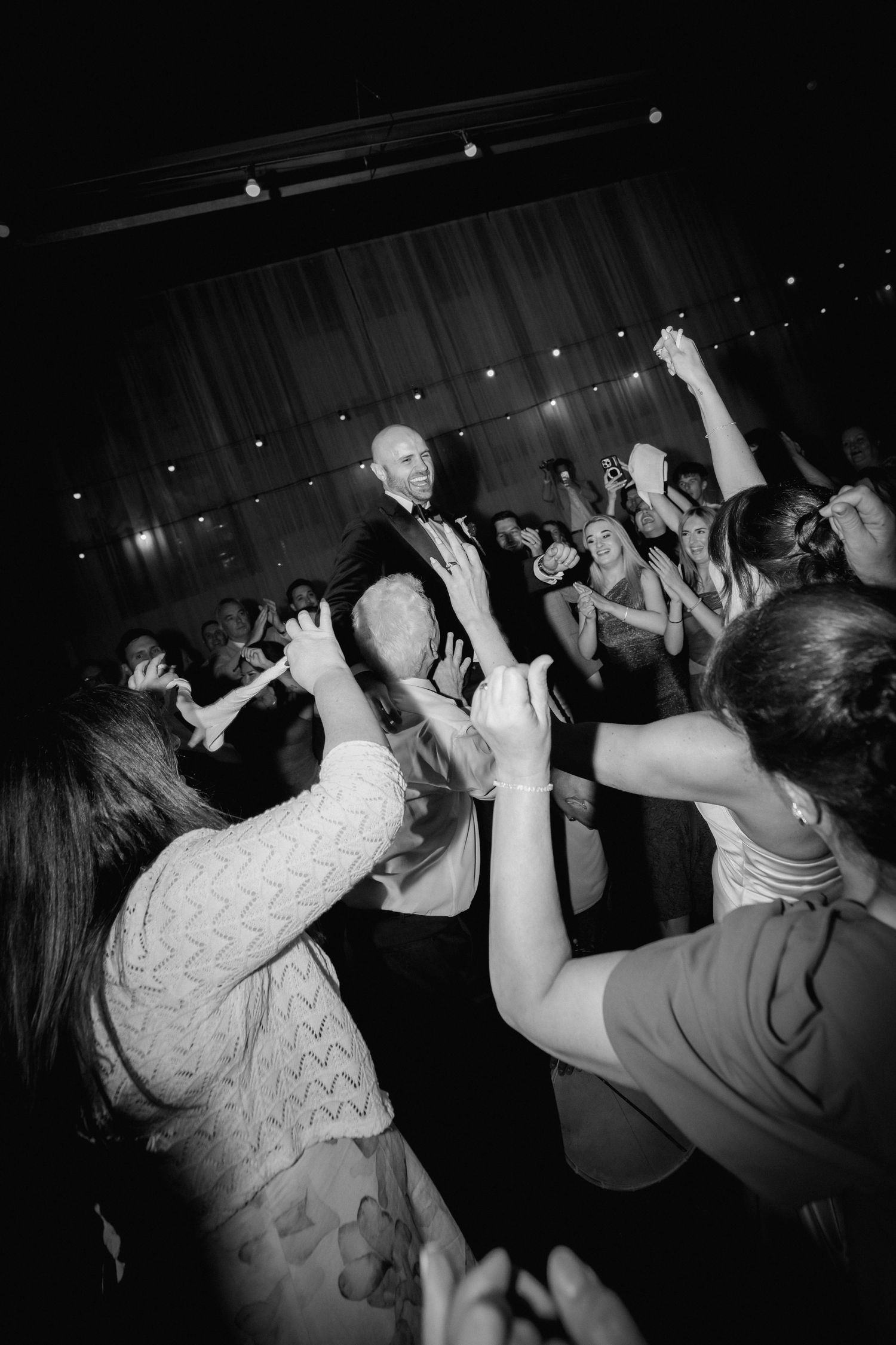 Black and white photos show people dancing with raised arms at a lively party or nightclub event.