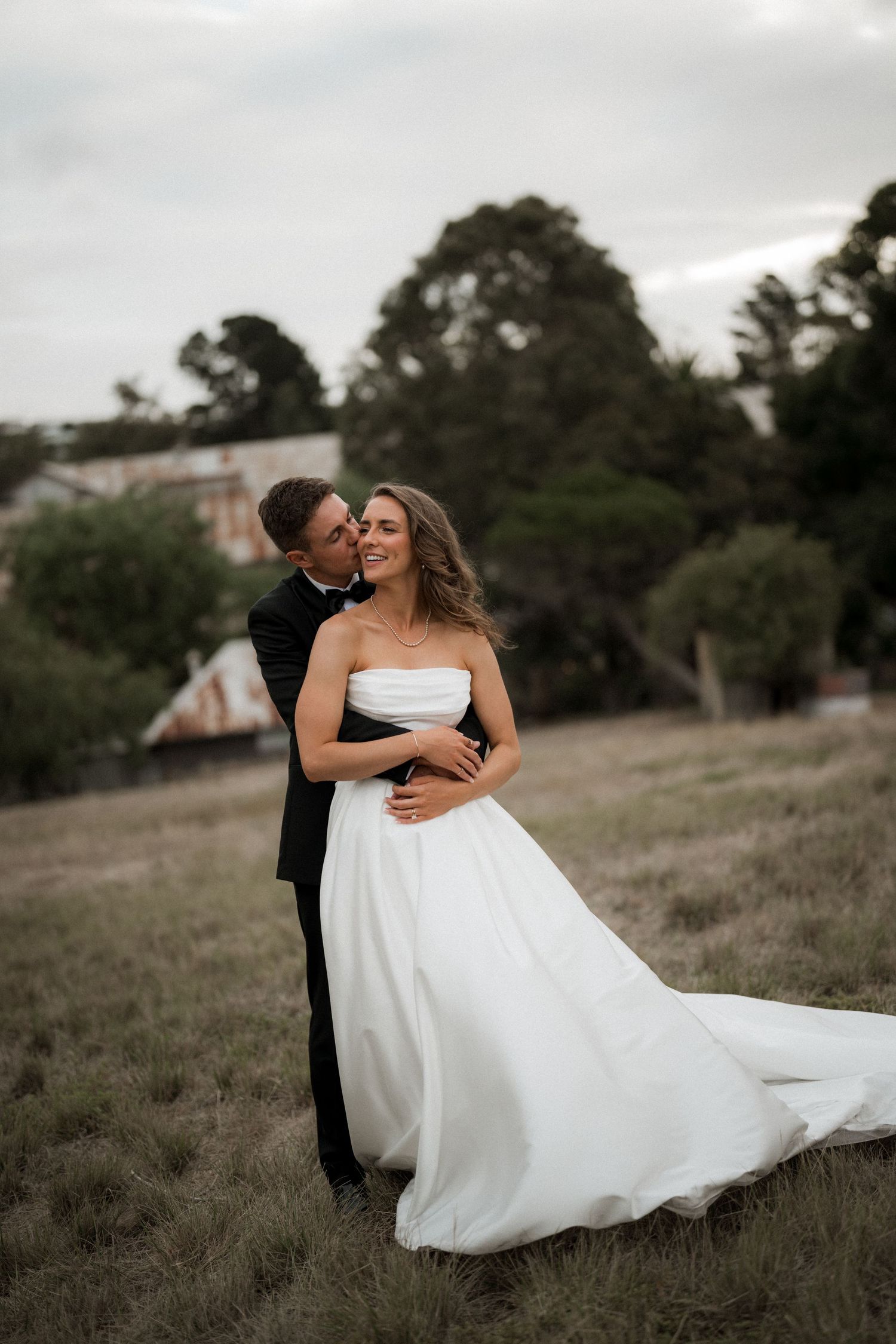 A series of romantic wedding photos in a field showing intimate moments between the bride and groom.