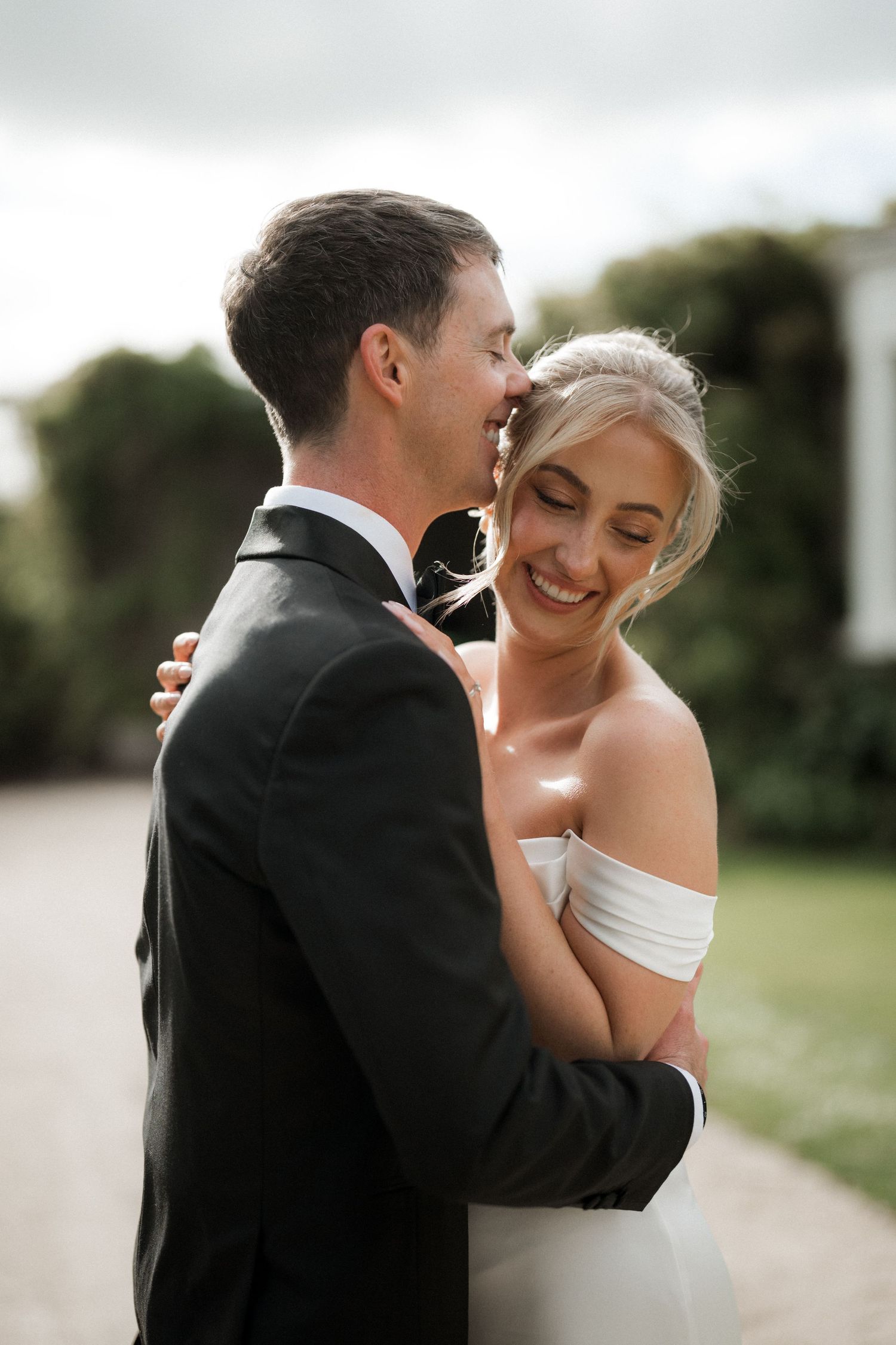 Romantic wedding portraits captured against a soft outdoor background.