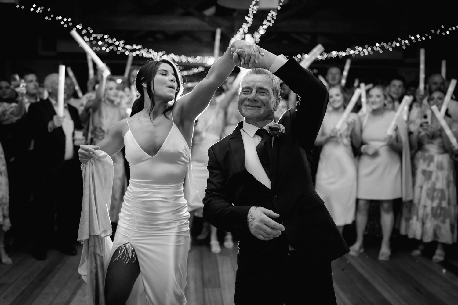 Wedding reception dance party with string lights creating a magical atmosphere.