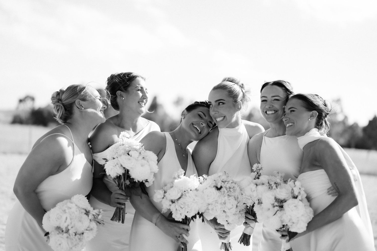 Bridal party holding white bouquets in a series of black and white portrait shots.