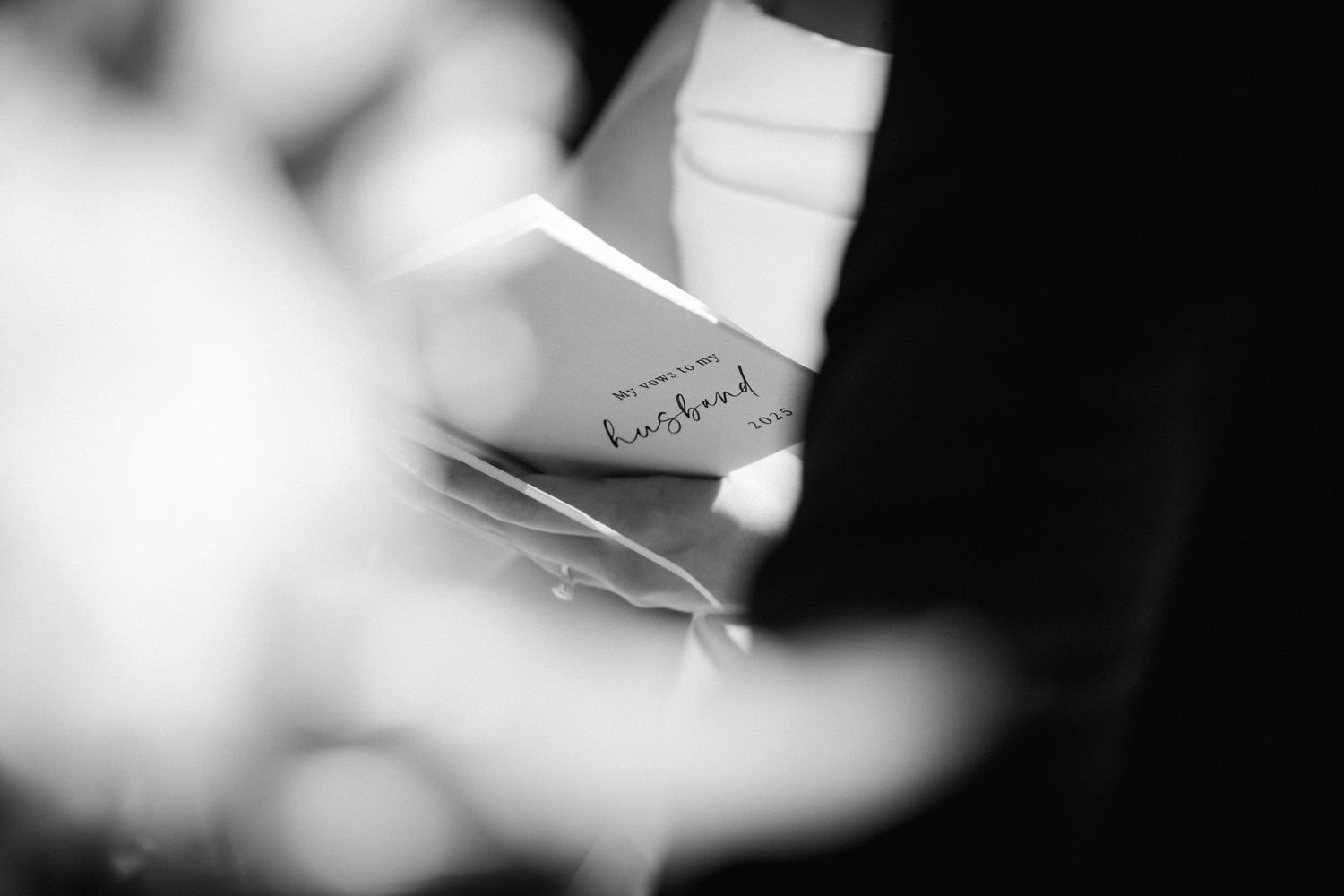 Black and white macro shot of a pen writing on paper with shallow depth of field.