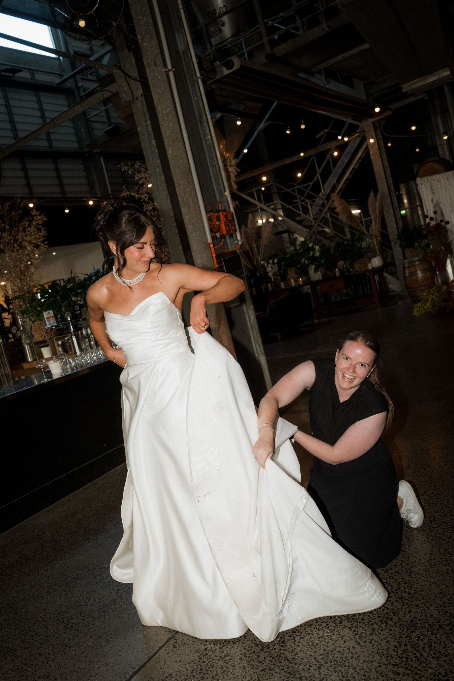 Playful sequence of a bride lifting her wedding dress while dancing at a reception.