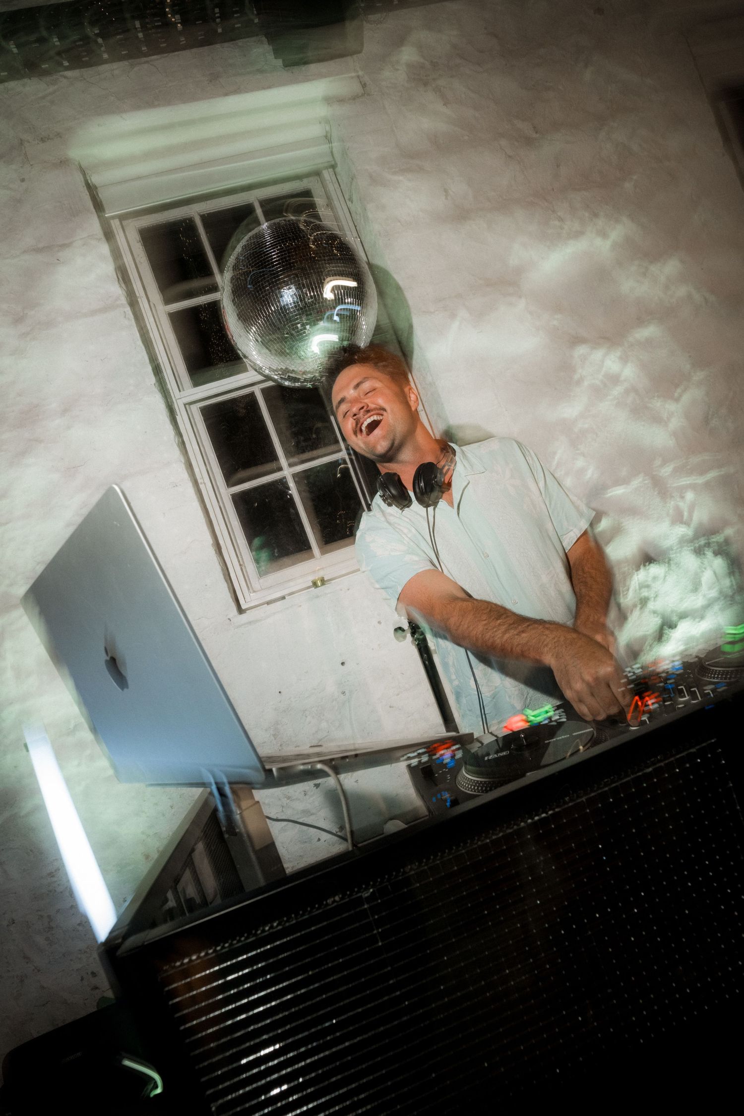 DJ performs at a wedding reception with dramatic lighting and equipment setup.