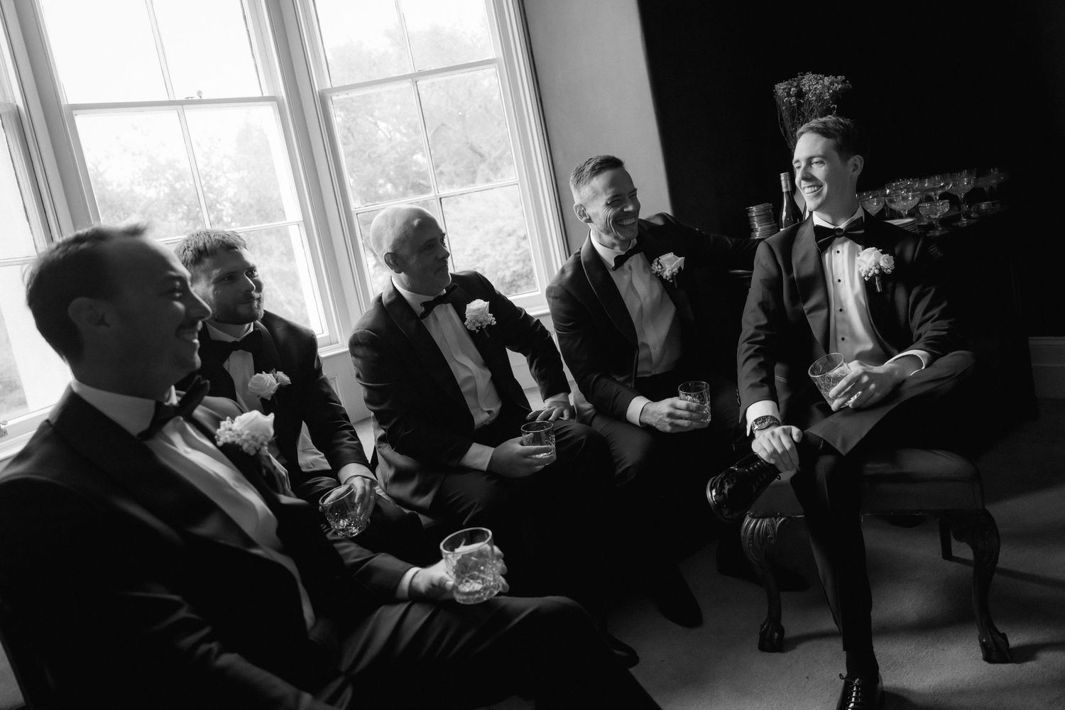 Black and white photo sequence of wedding guests seated and mingling in formal attire.