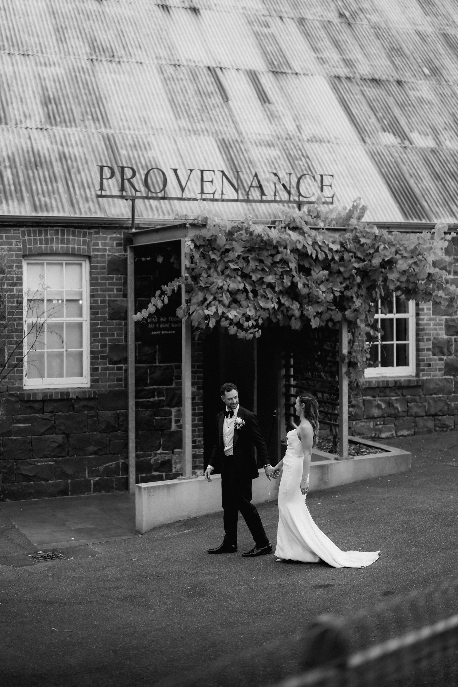 Black and white wedding photos showing a couple walking outside a brick building with a Provenance sign.