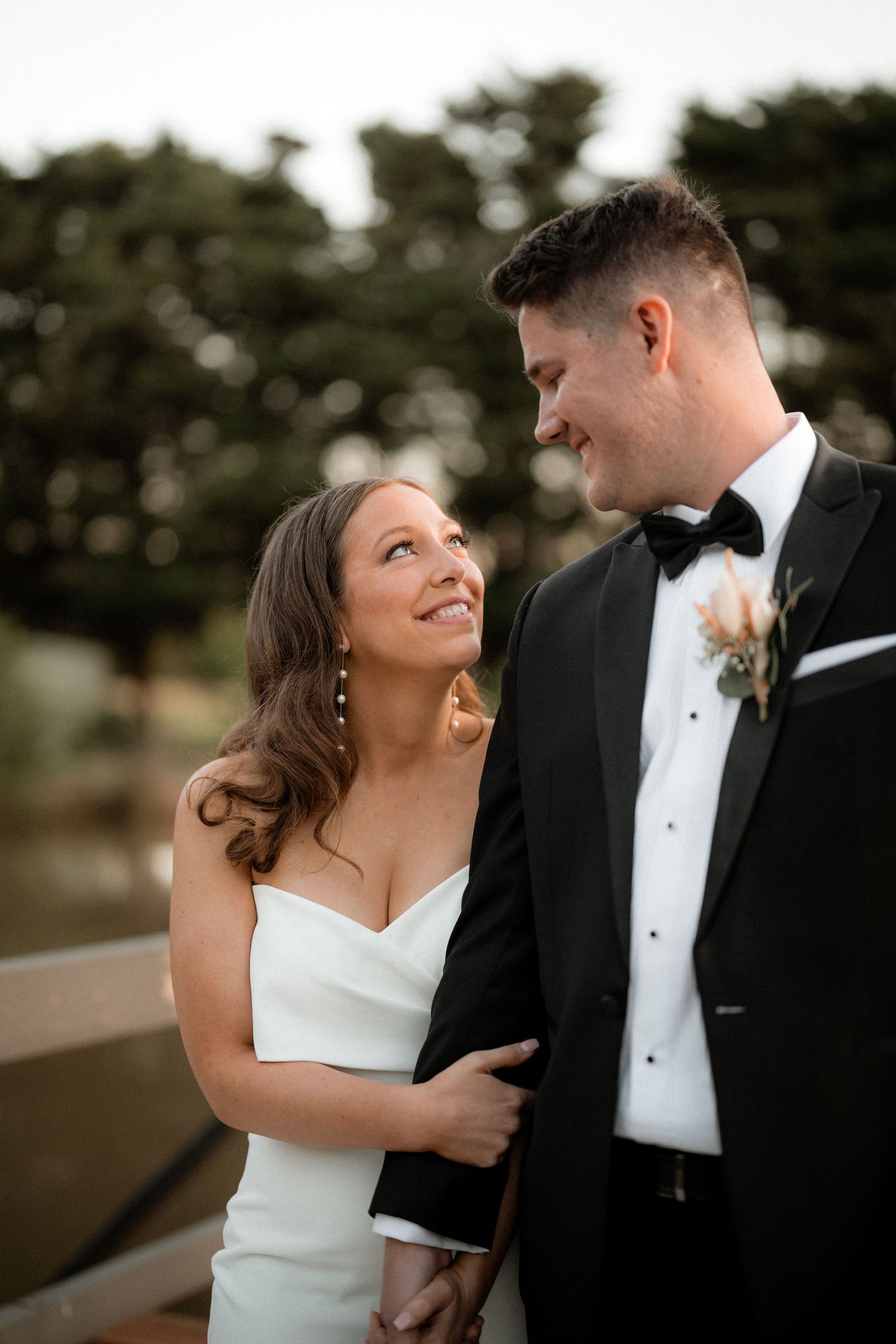 Candid wedding portraits show joyful moments between couple in classic black tie and white dress.