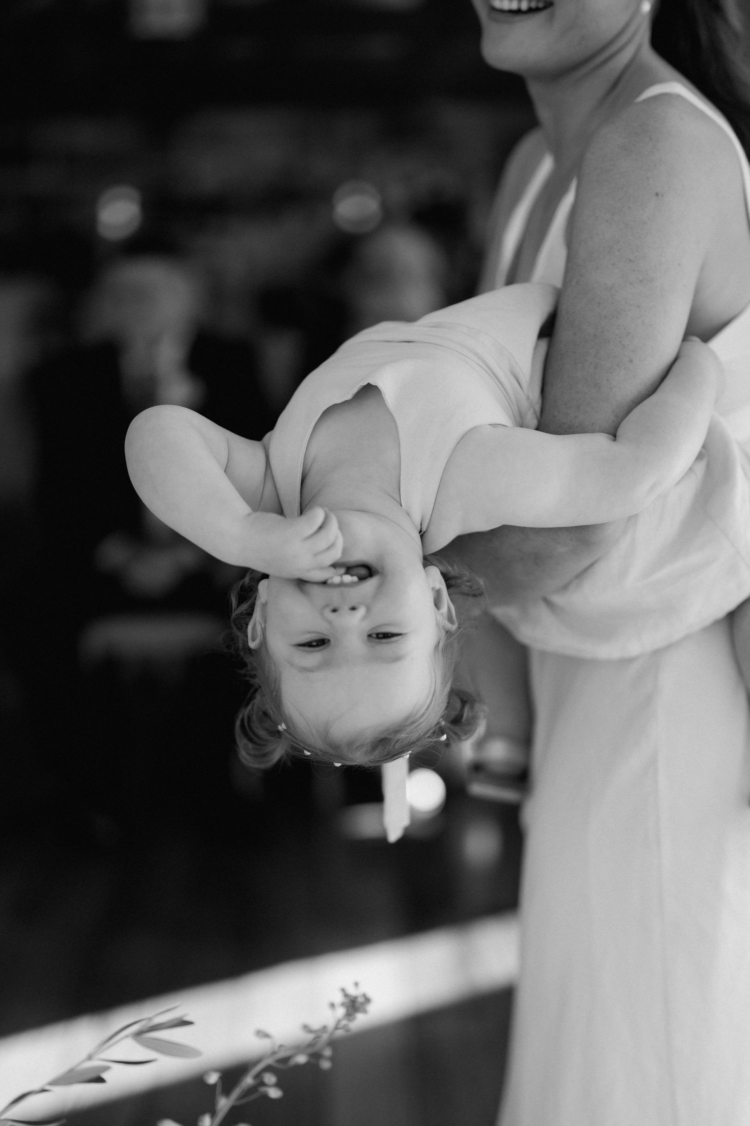 A couple dancing together during their first dance at a wedding reception in black and white.