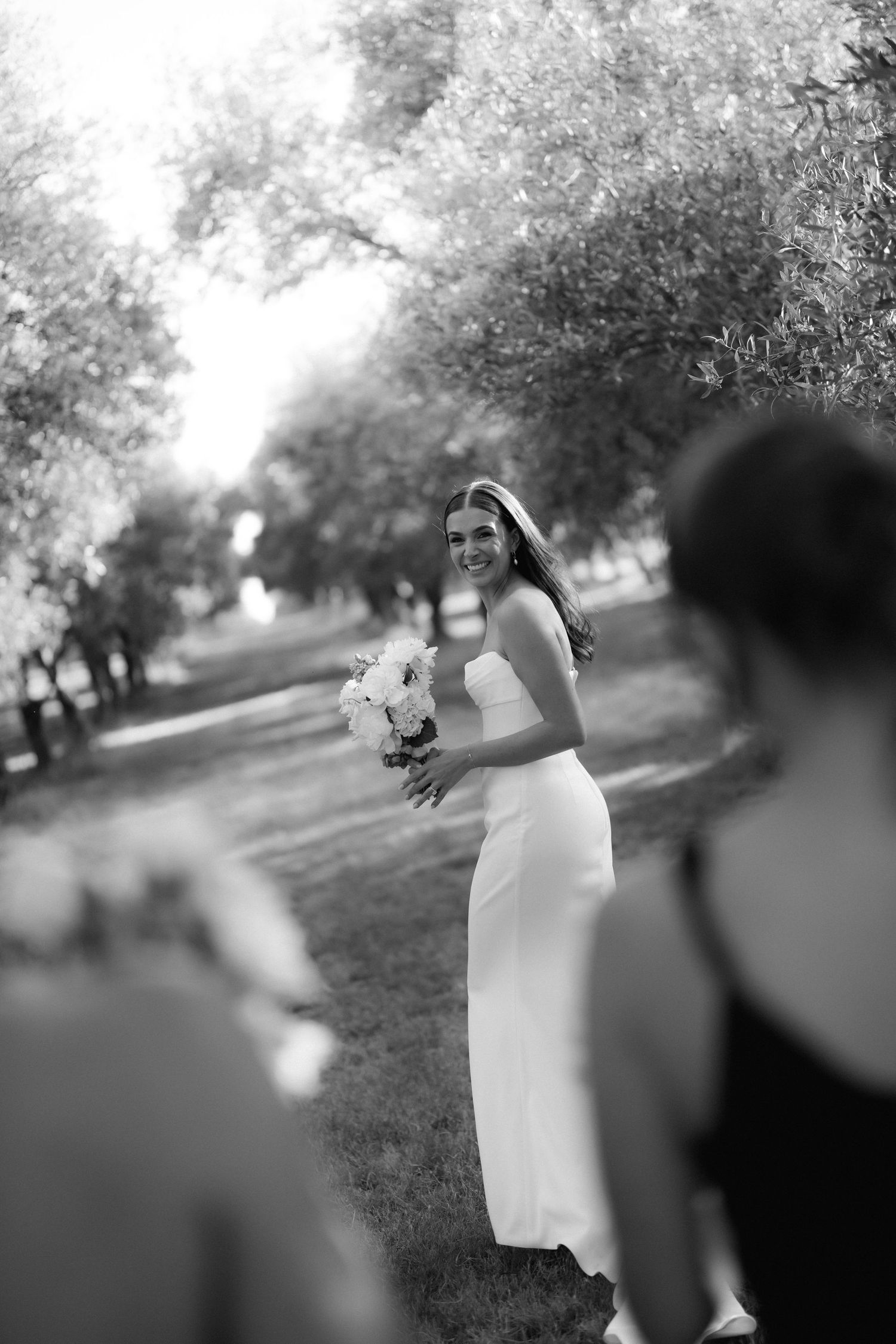 Elegant outdoor wedding photography session with flowing white dress against natural scenery.