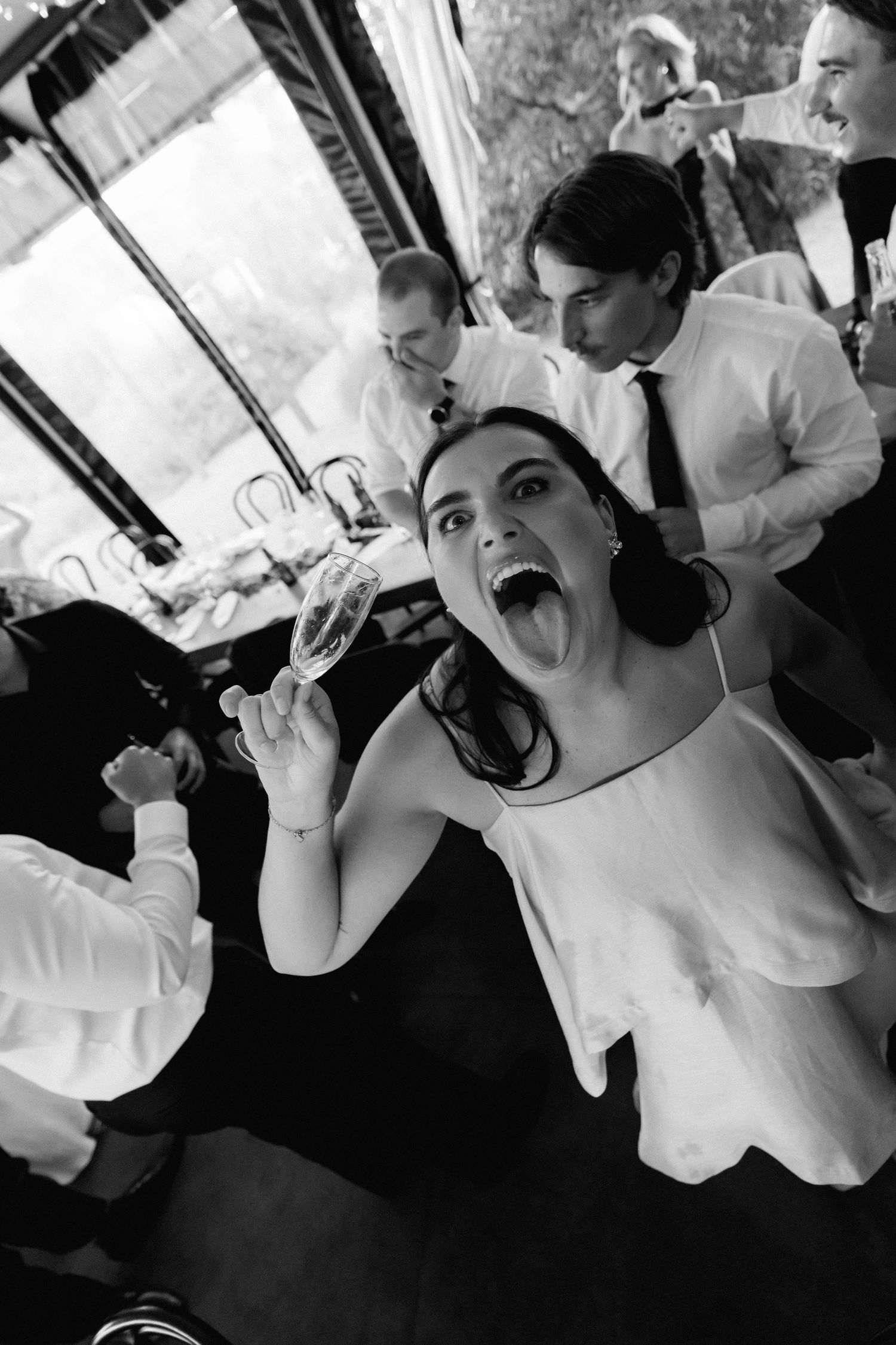 Black and white candid photos of wedding party making silly faces.