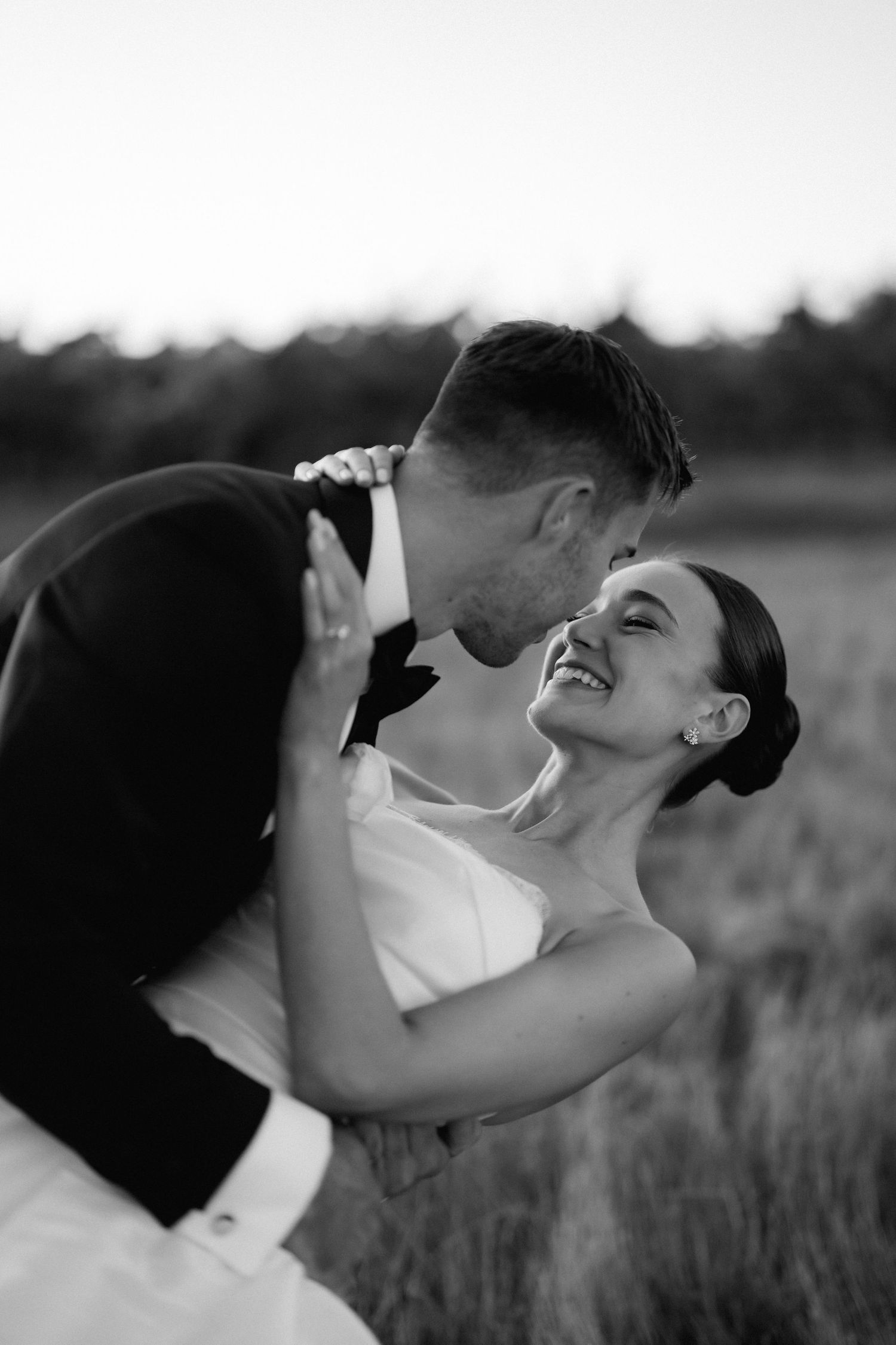 Black and white romantic portraits captured in natural field setting.
