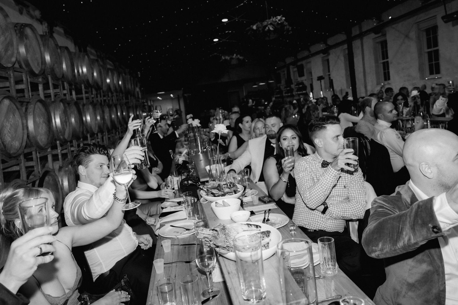 A series of black and white photos showing people dining and socializing at a busy restaurant gathering.
