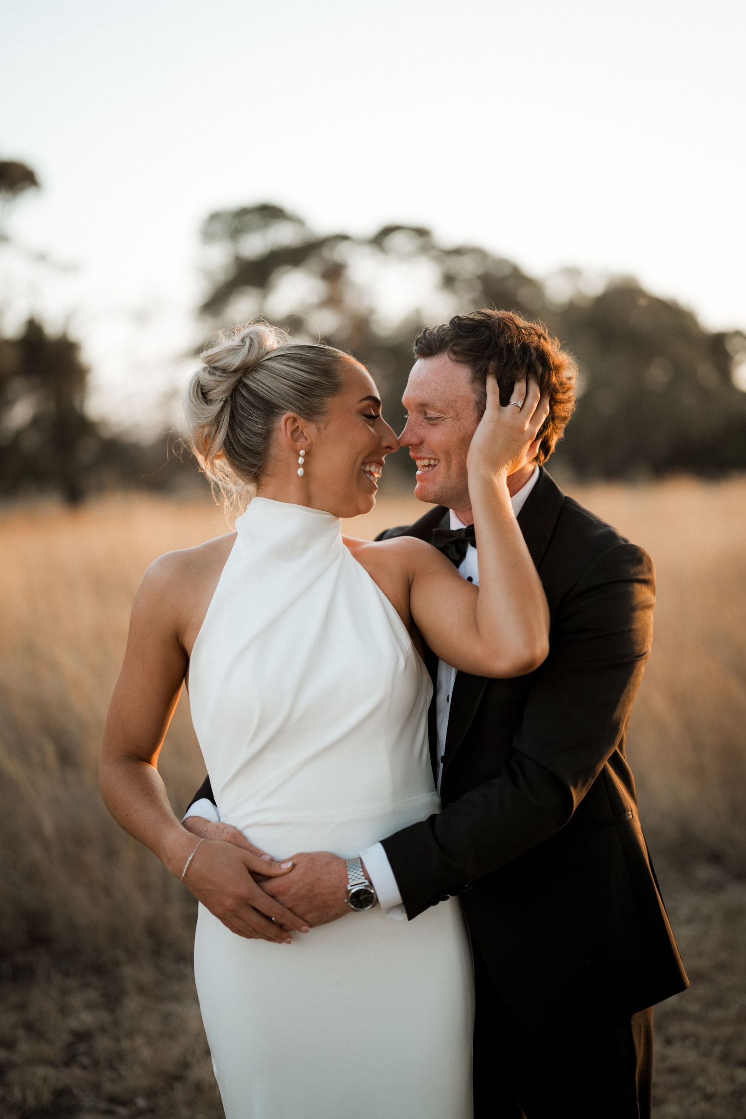 Romantic sunset wedding portraits captured in a golden field.
