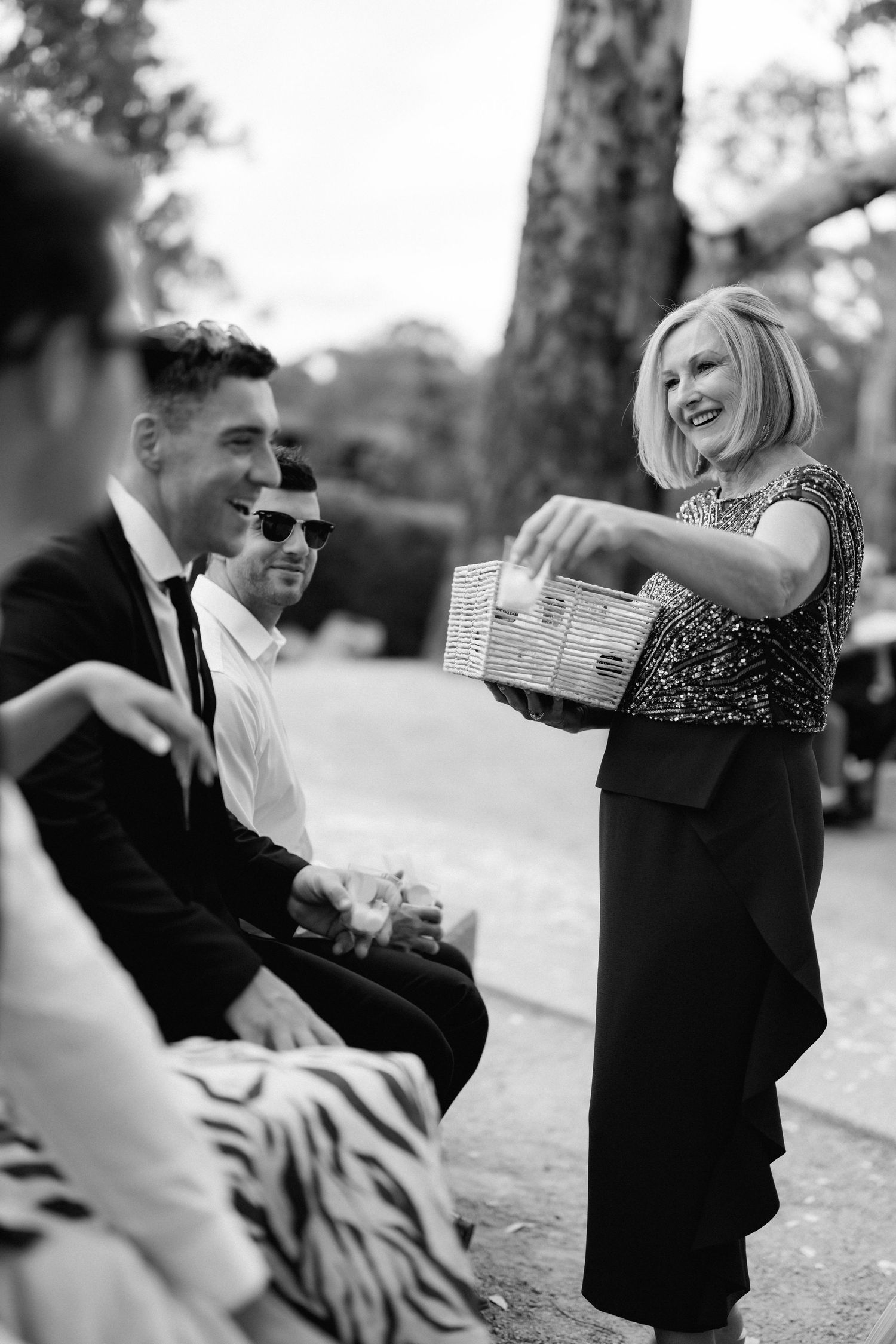 Black and white sequence of guests pouring and sharing champagne outdoors.