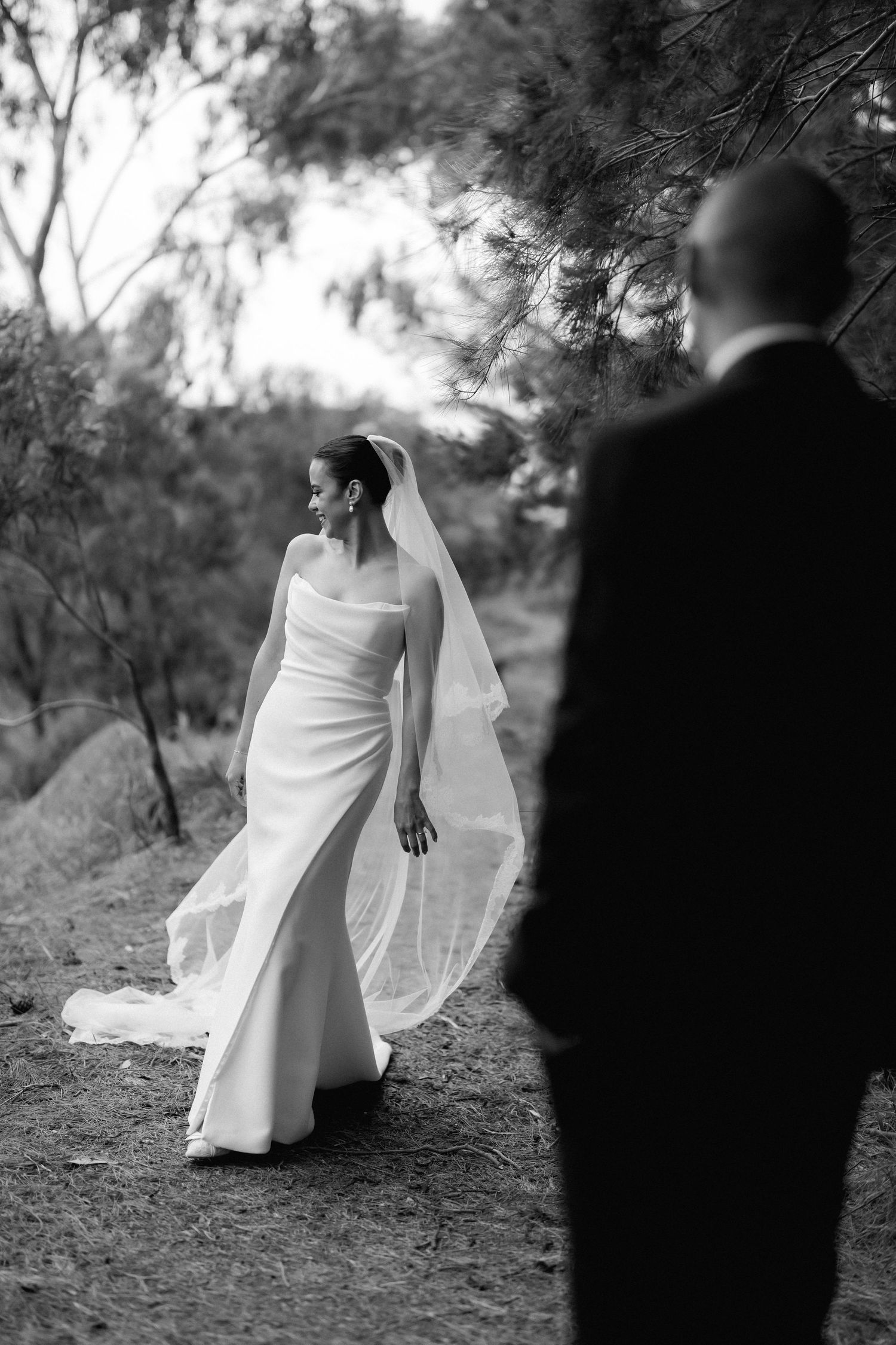 Artistic black and white sequence capturing bride's flowing dress against natural outdoor backdrop.