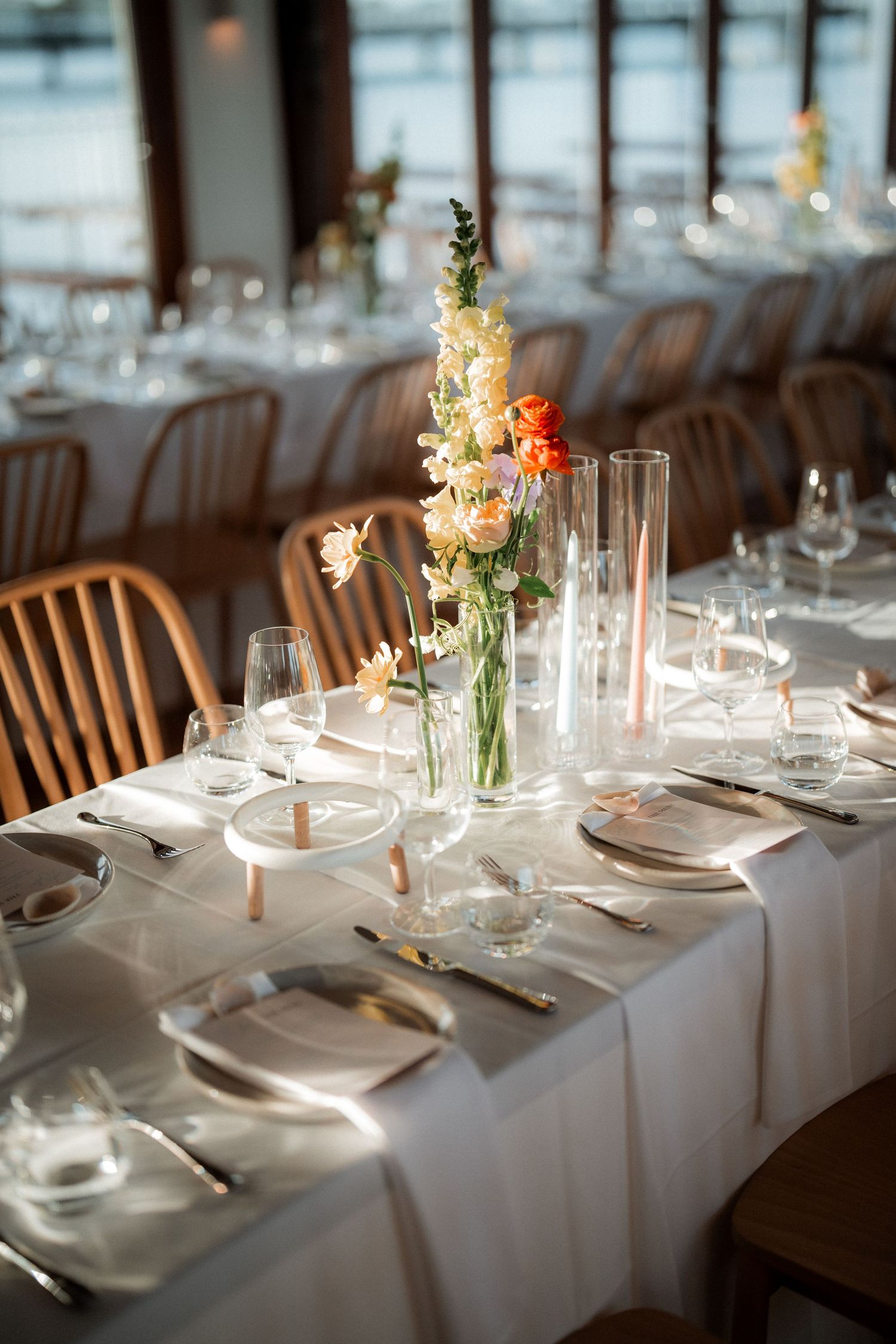 Elegant wedding reception table setting with white linens and delicate floral centerpieces.