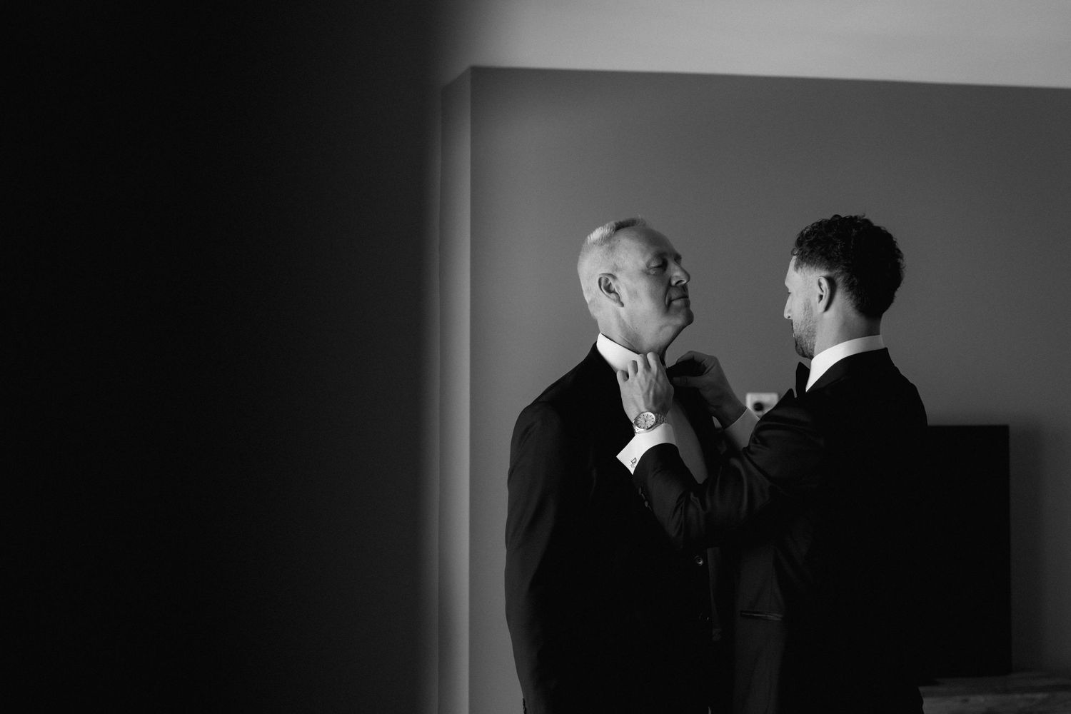An elegant black and white indoor wedding ceremony with dramatic lighting and silhouettes.