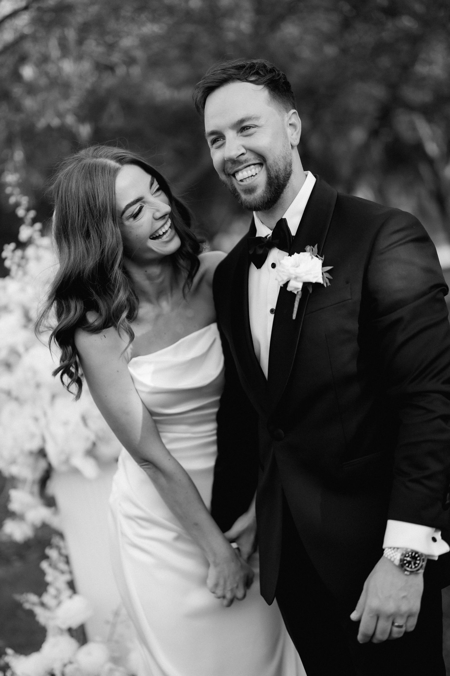 Black and white candid wedding portraits showing joyful laughter and natural moments.