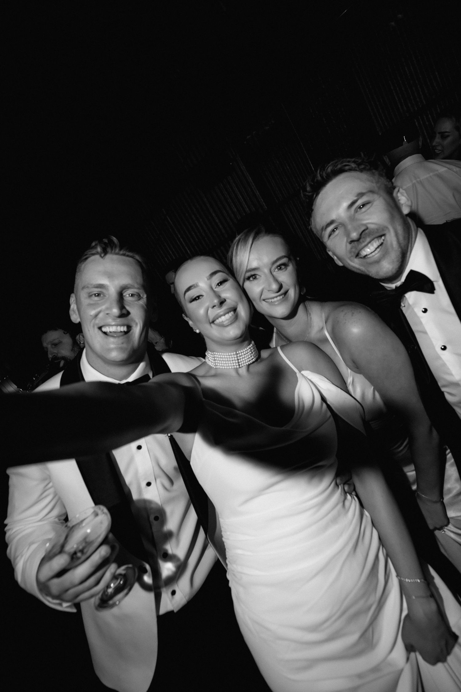 A group of people in formal attire posing together in black and white photography.