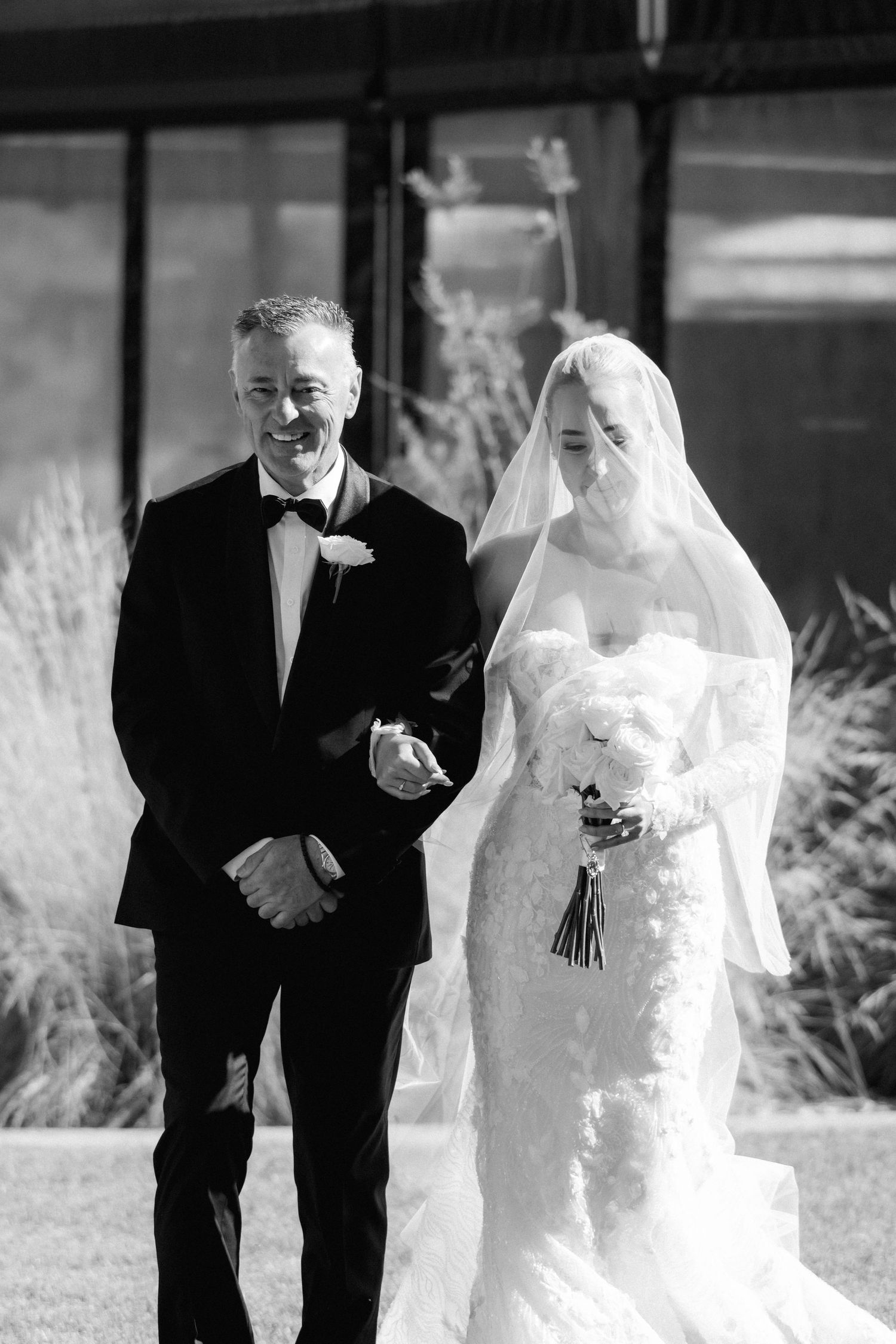 Black and white wedding processional photos showing a walk down an outdoor pathway.
