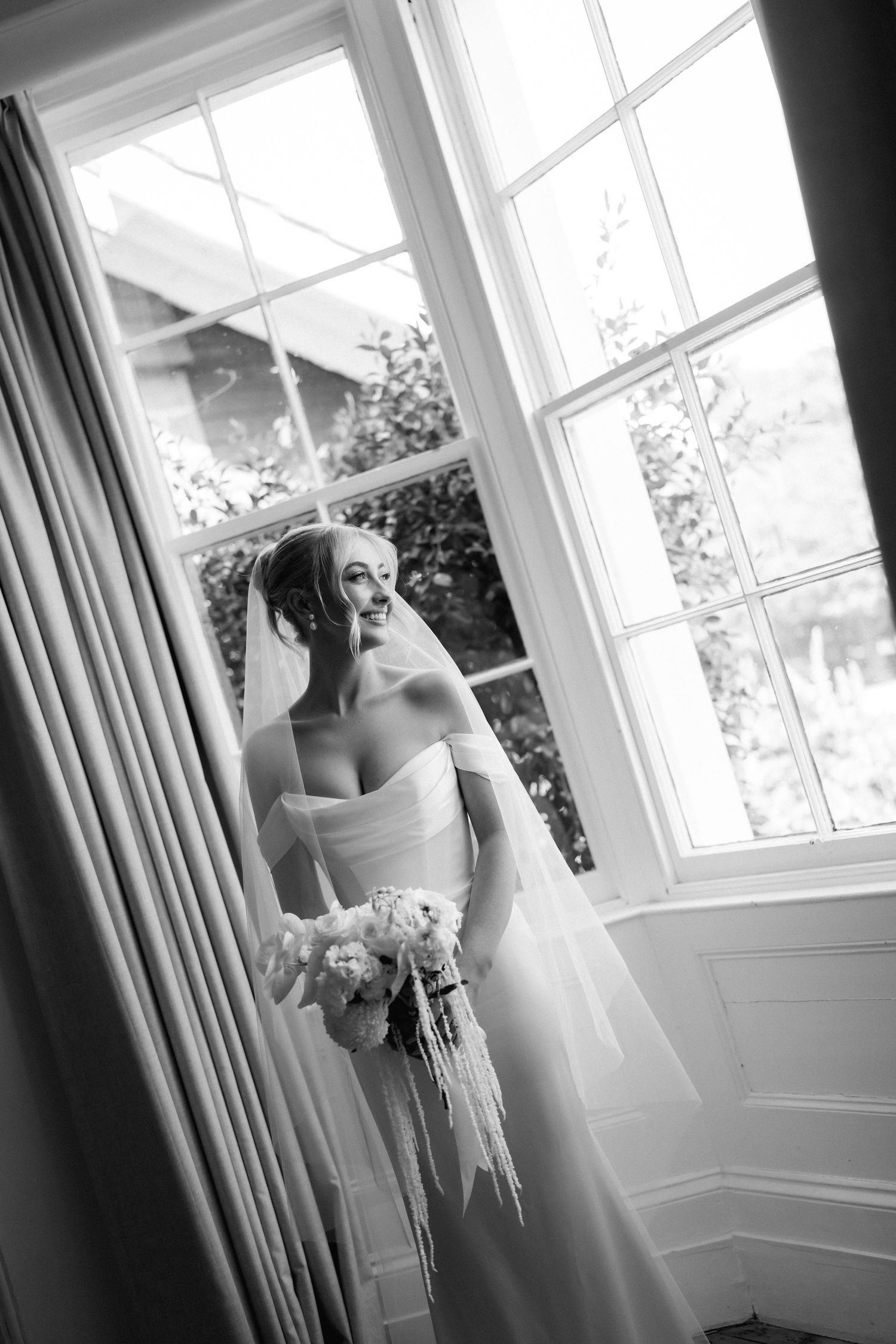 Elegant black and white photo series of a bride getting ready by a bright window.