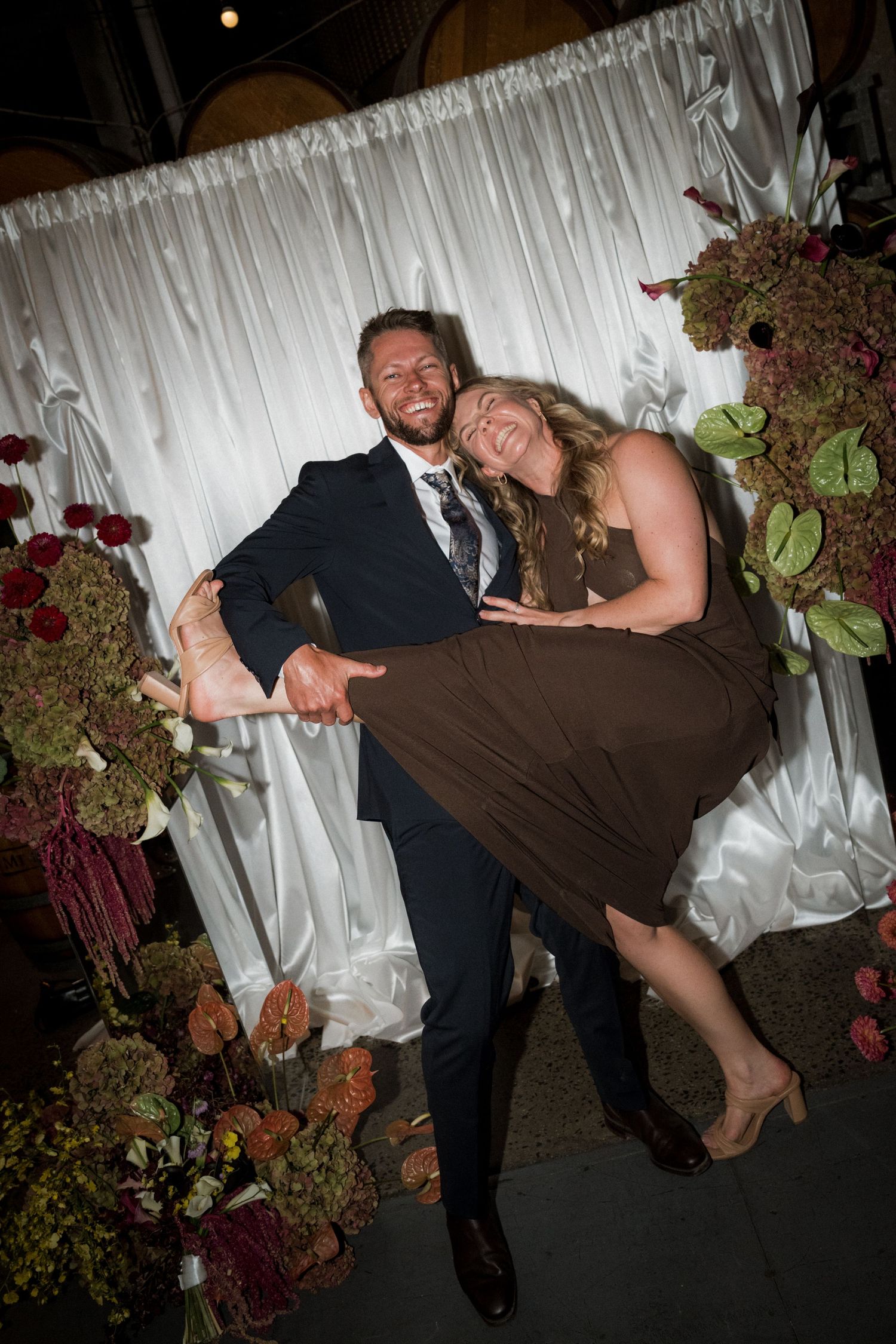 Couple performing a dramatic dance dip pose at their wedding reception.