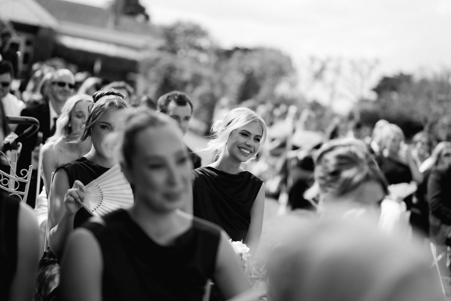 Black and white photos show a crowd of people celebrating and cheering at an outdoor event.