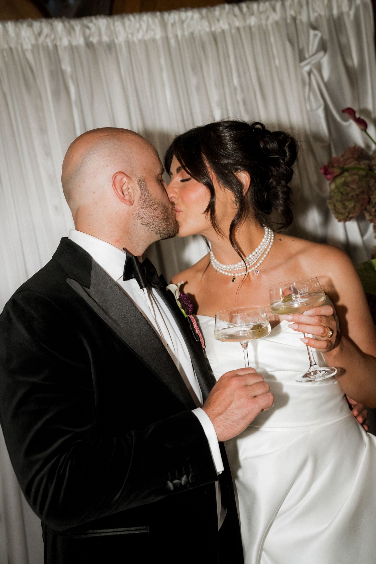 Romantic champagne toast sequence between newlyweds against white backdrop.