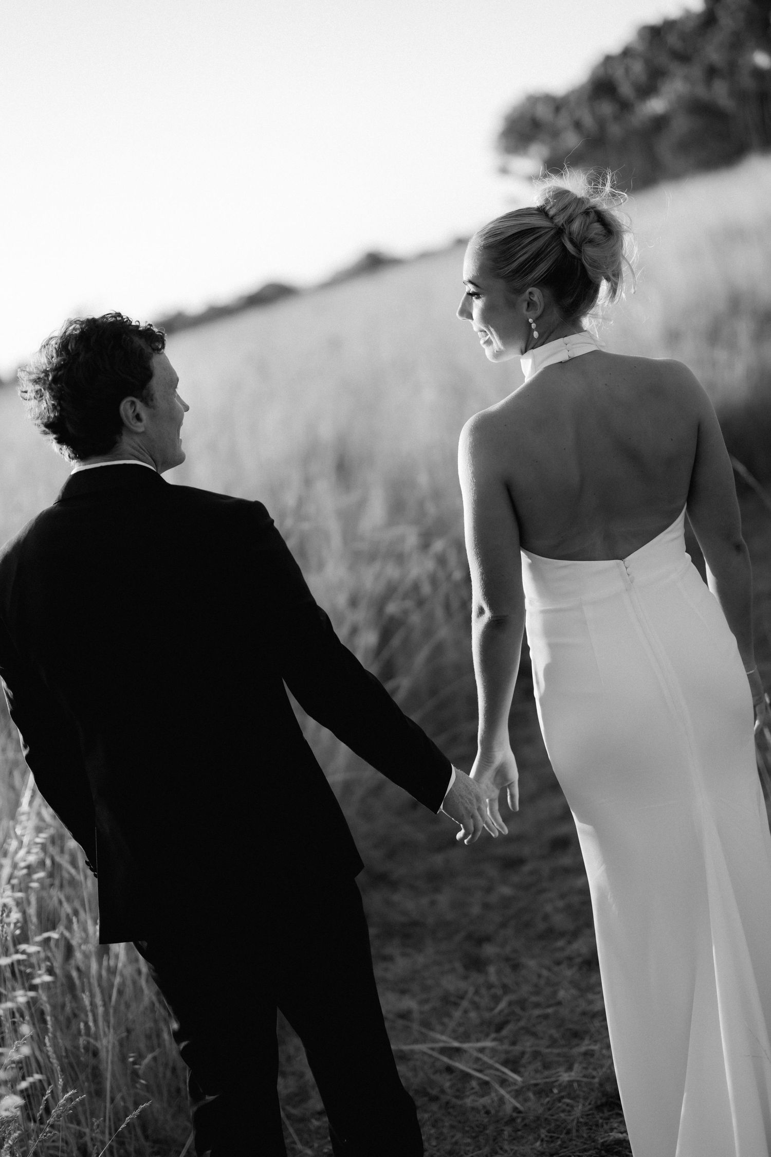 Artistic black and white silhouette of couple walking together in natural setting.