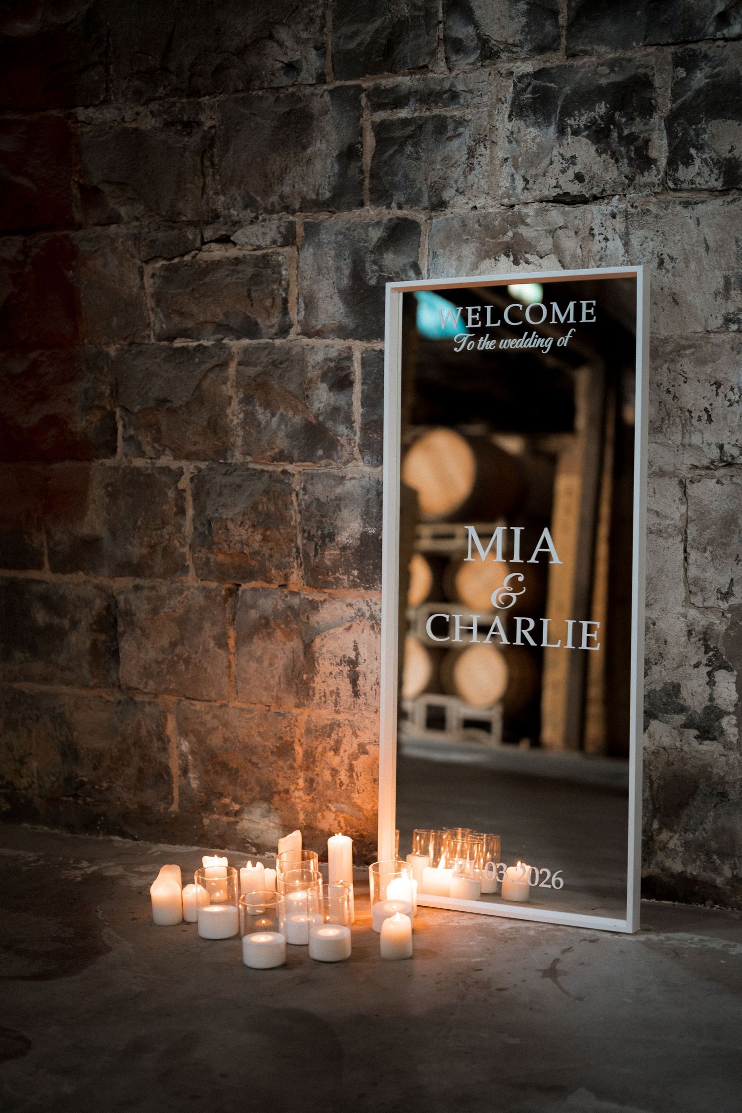 Welcome signs illuminated by candlelight against a rustic brick wall background.