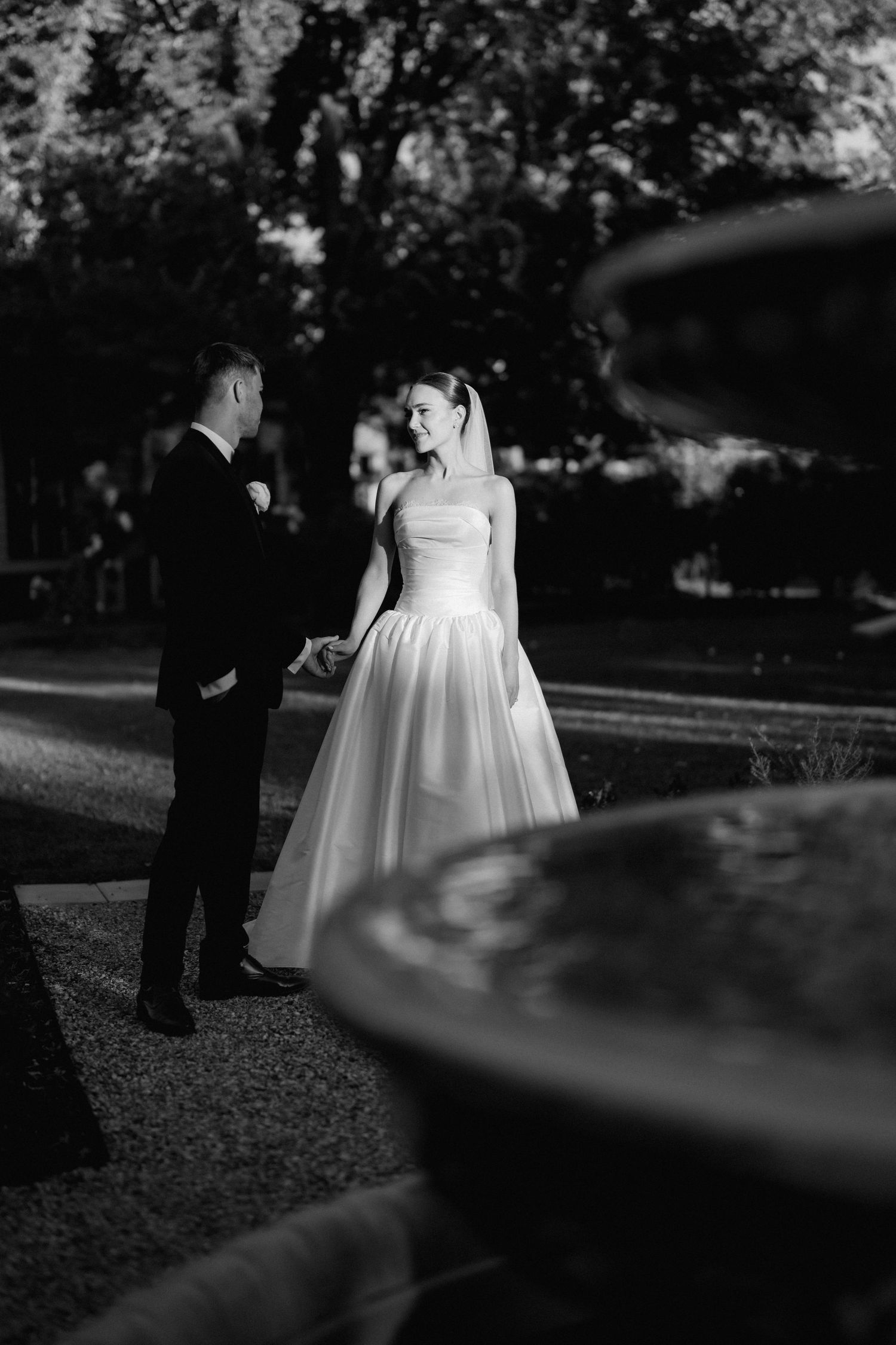 Artistic black and white wedding photography sequence showing couple in garden setting.