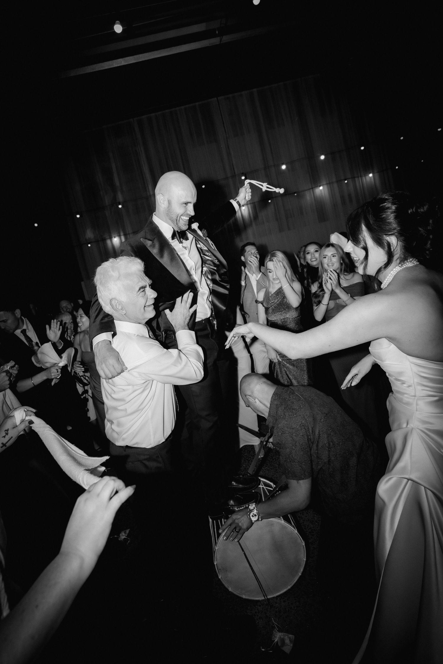 A sequence of black and white photos showing people dancing energetically at what appears to be a wedding reception or party.