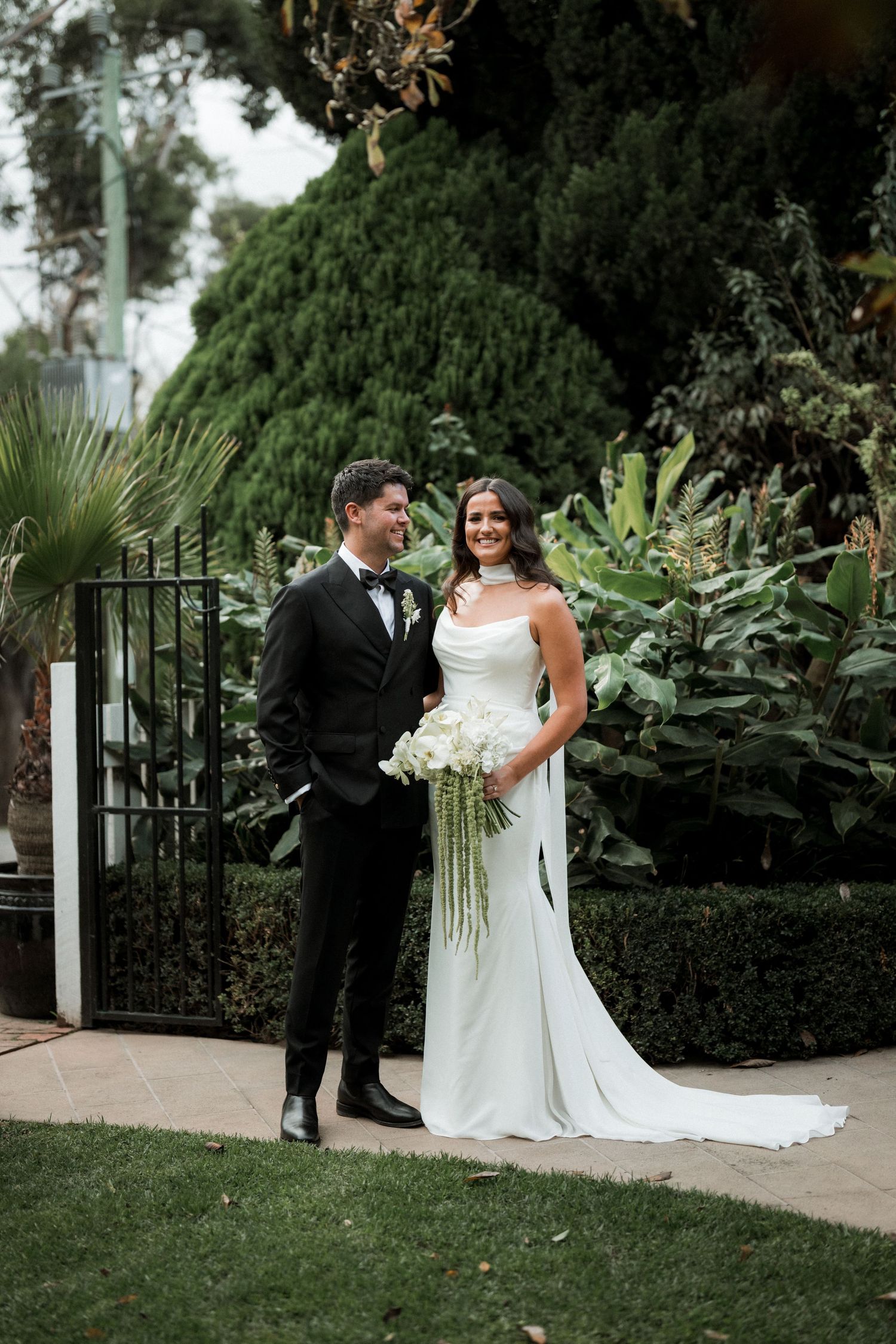 Bride and groom share intimate moments in a lush garden setting during their wedding photo session.