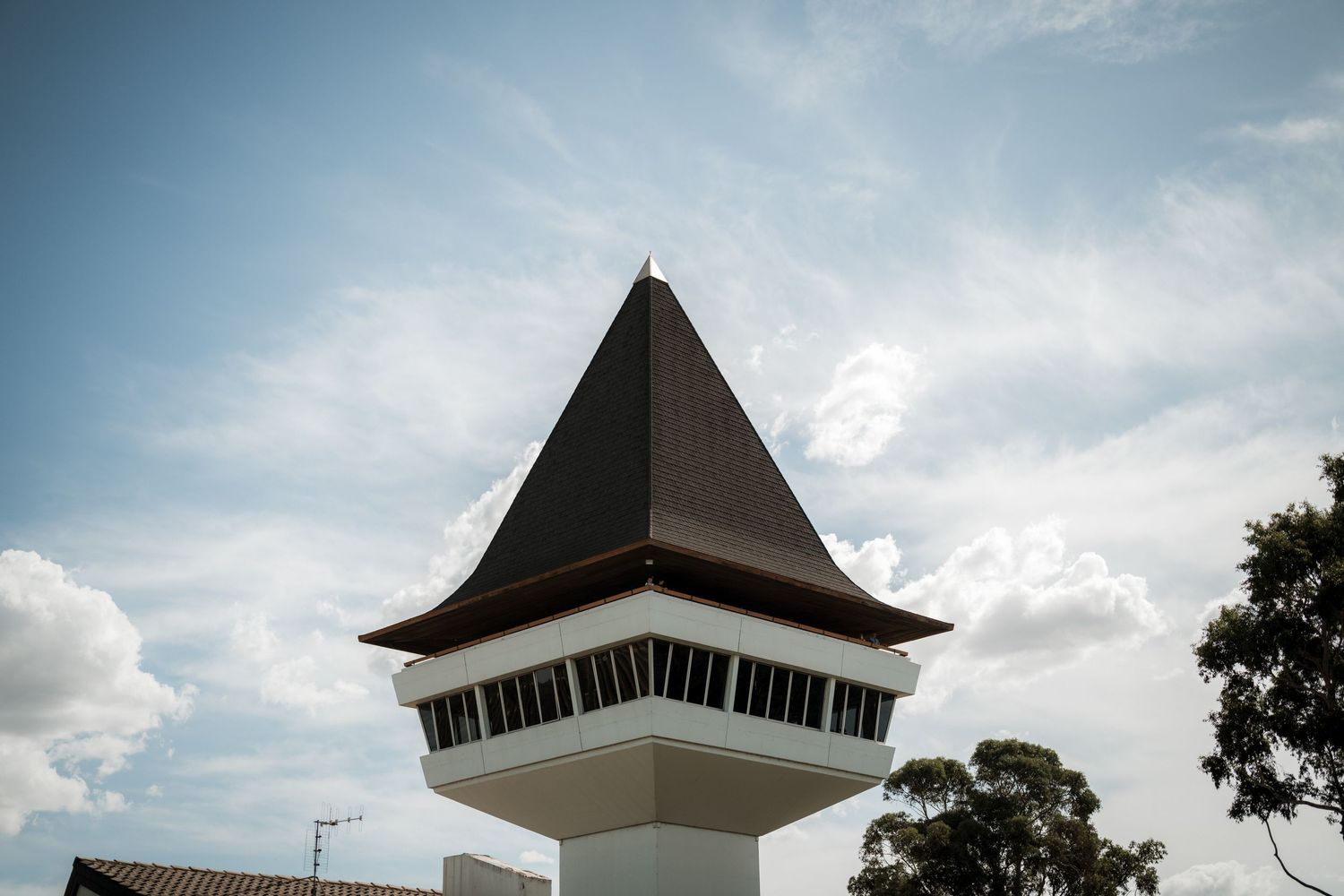 Dramatic cloudy sky frames the pointed spires and rooflines of traditional Asian-style pagoda architecture.