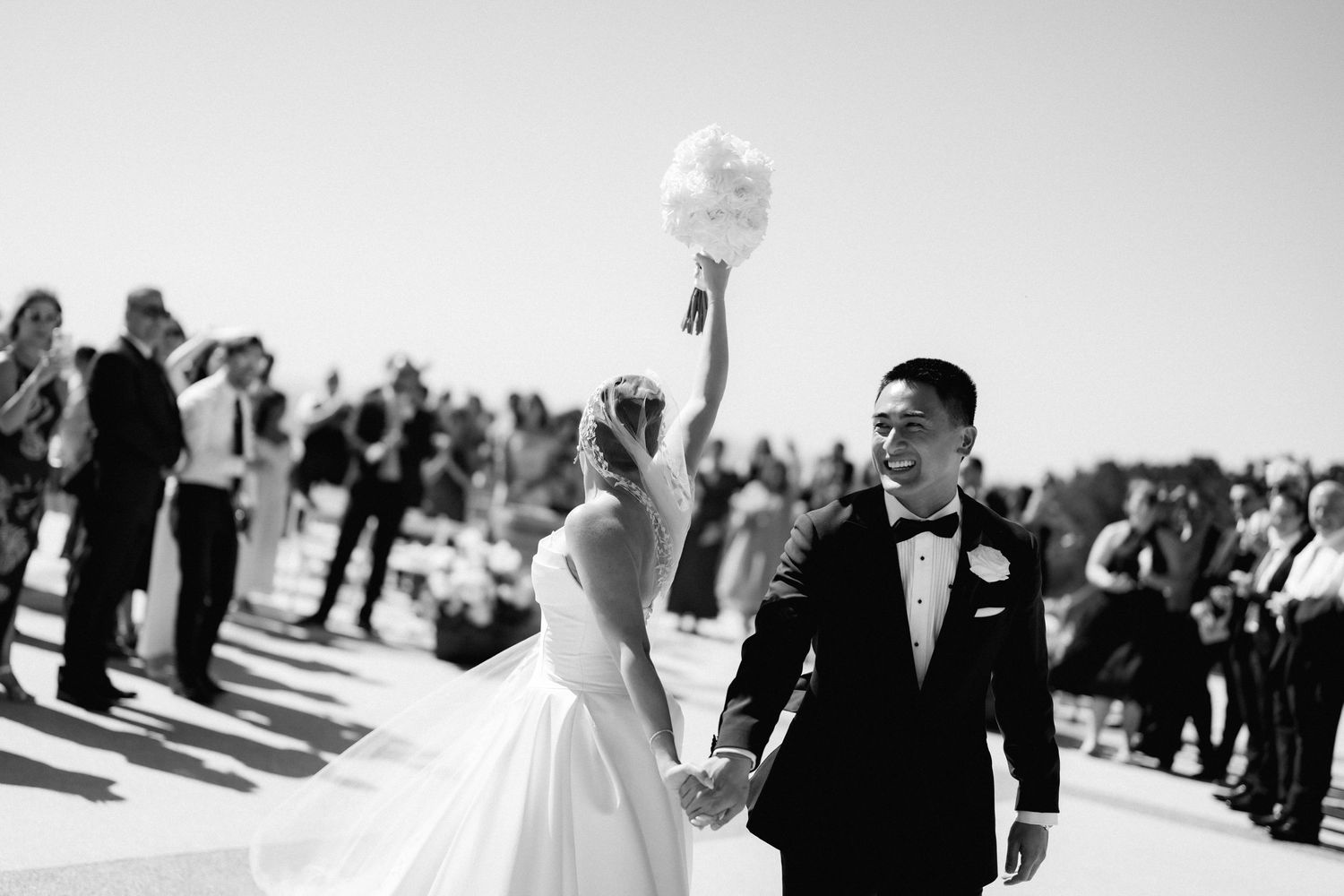 A black and white wedding photo montage showing candid moments of celebration and joy during a ceremony and reception.