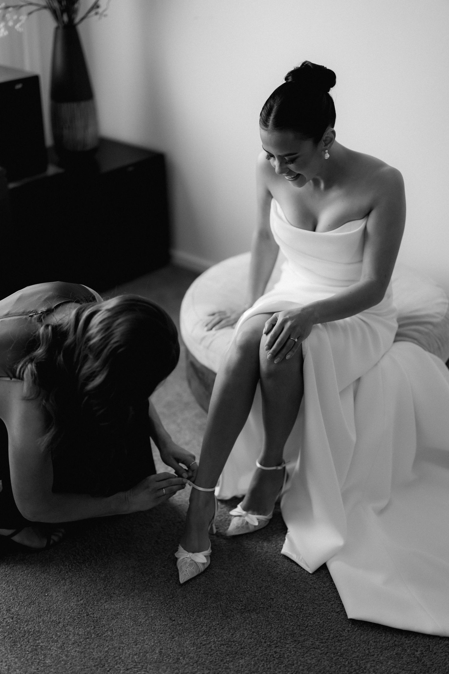 Black and white sequence showing a bride putting on her wedding shoes.