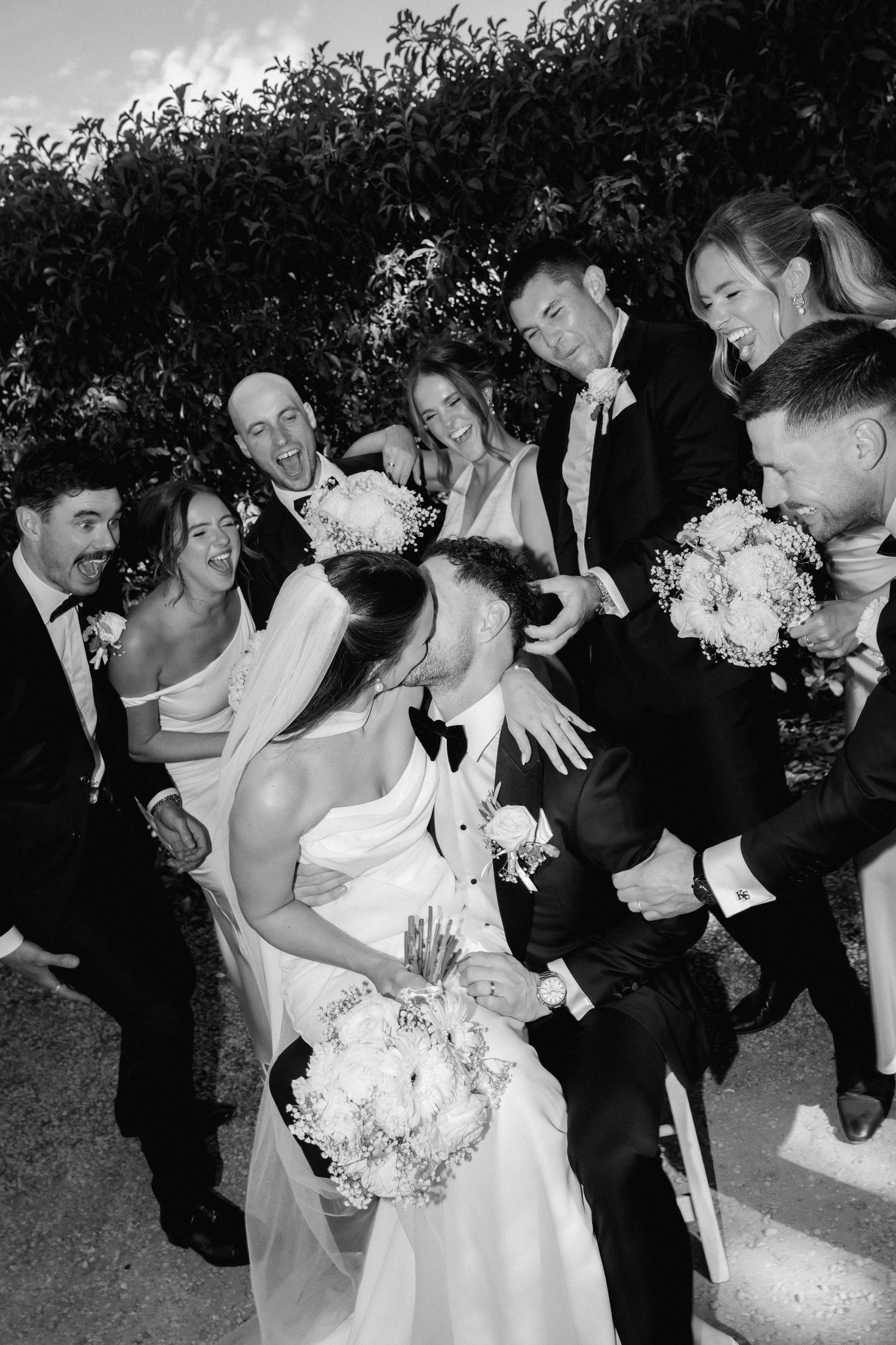 Black and white photo series showing a romantic dance dip sequence at an outdoor wedding celebration.