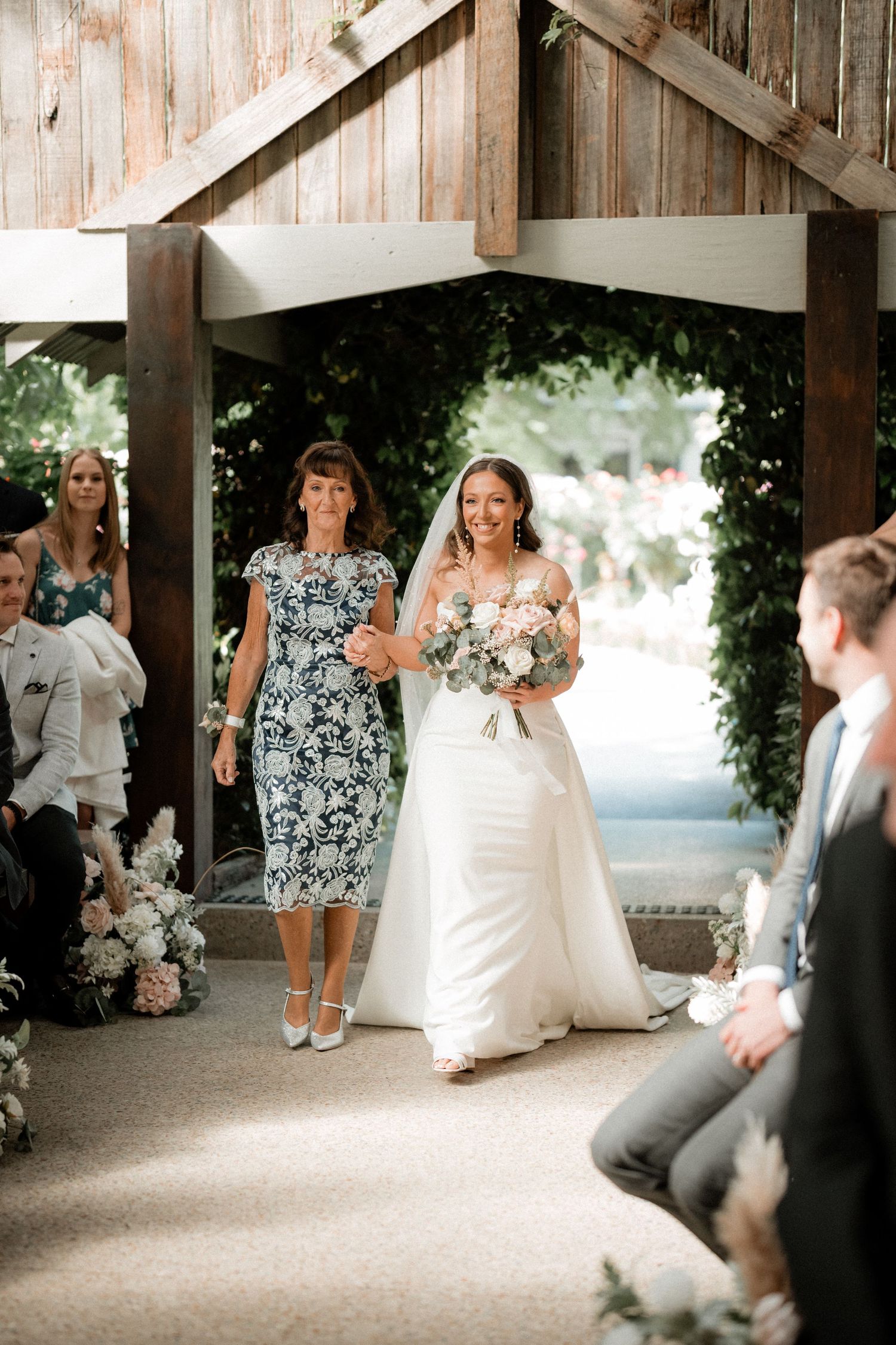 Wedding party relaxing and having fun in a rustic wooden barn venue with natural lighting.