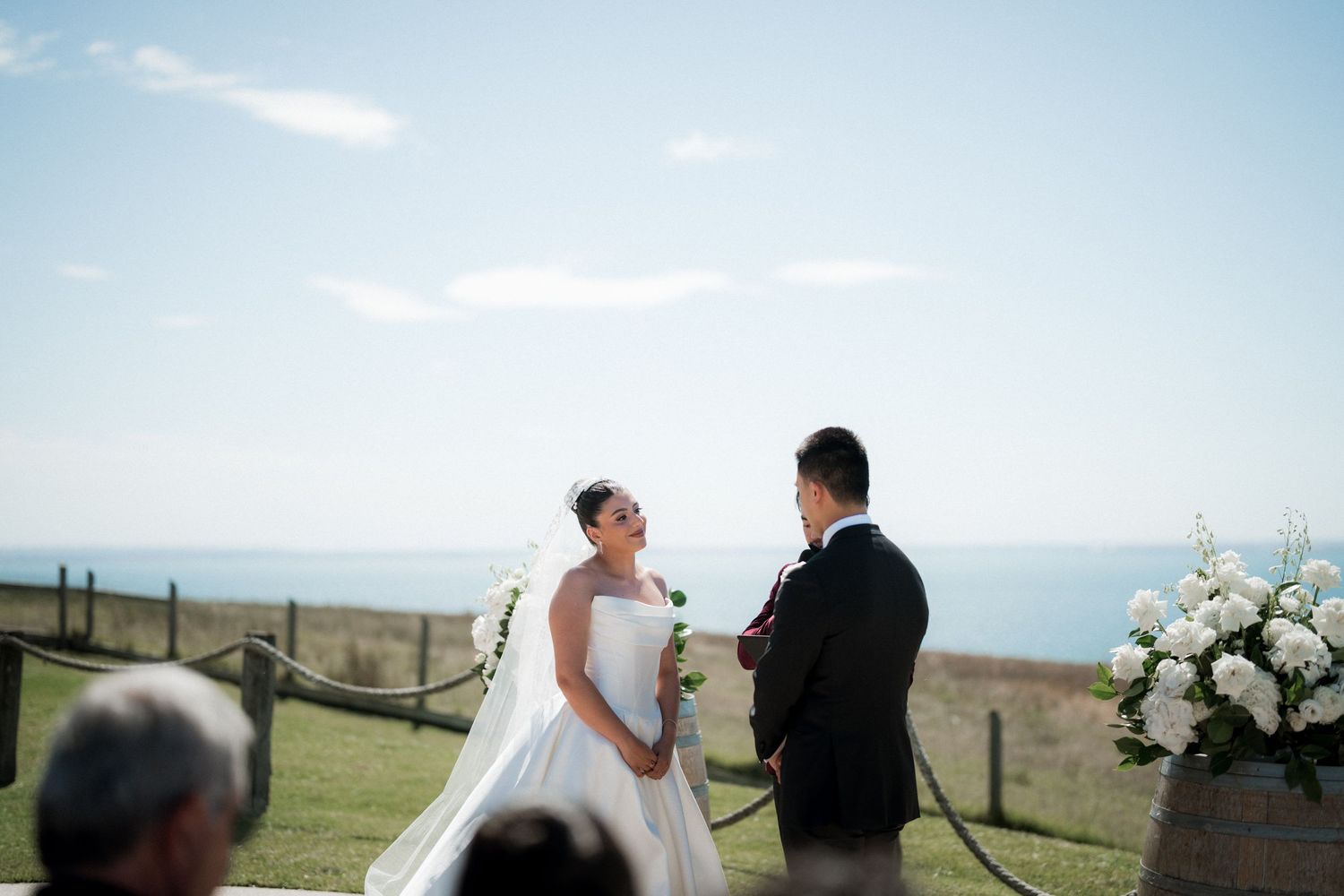 Couple exchanging vows during outdoor mountain wedding ceremony with scenic valley views in the background.
