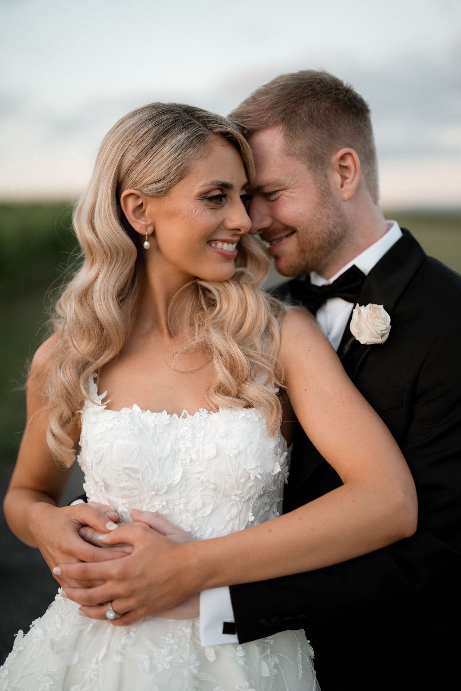 Intimate portrait of newlyweds sharing a tender moment at sunset.