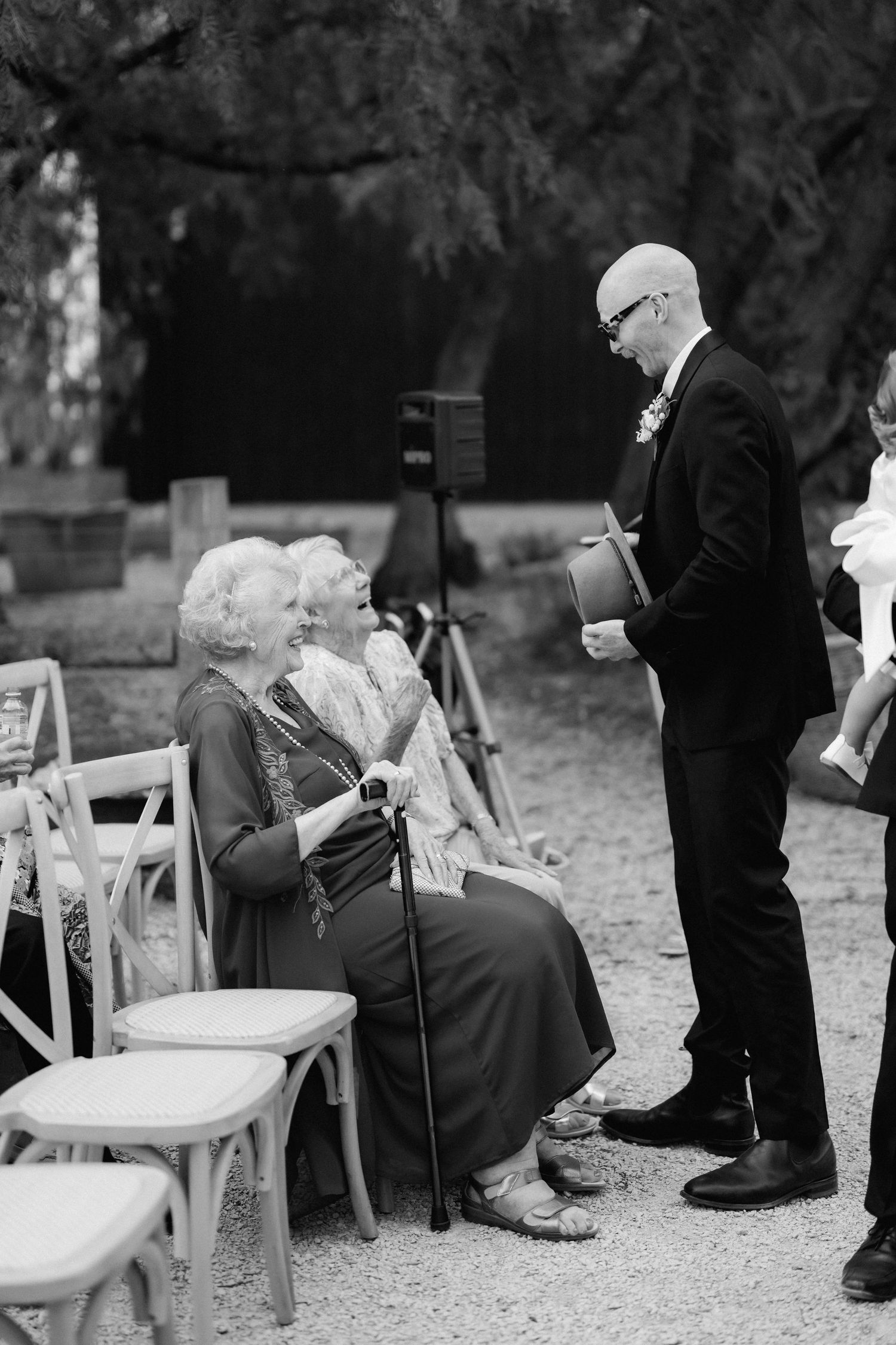 Wedding guests chatting before ceremony in outdoor garden setting.