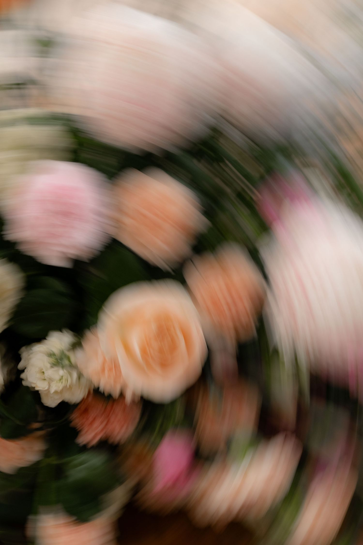 Abstract motion blur of pink and peach colored flowers creating an artistic effect.