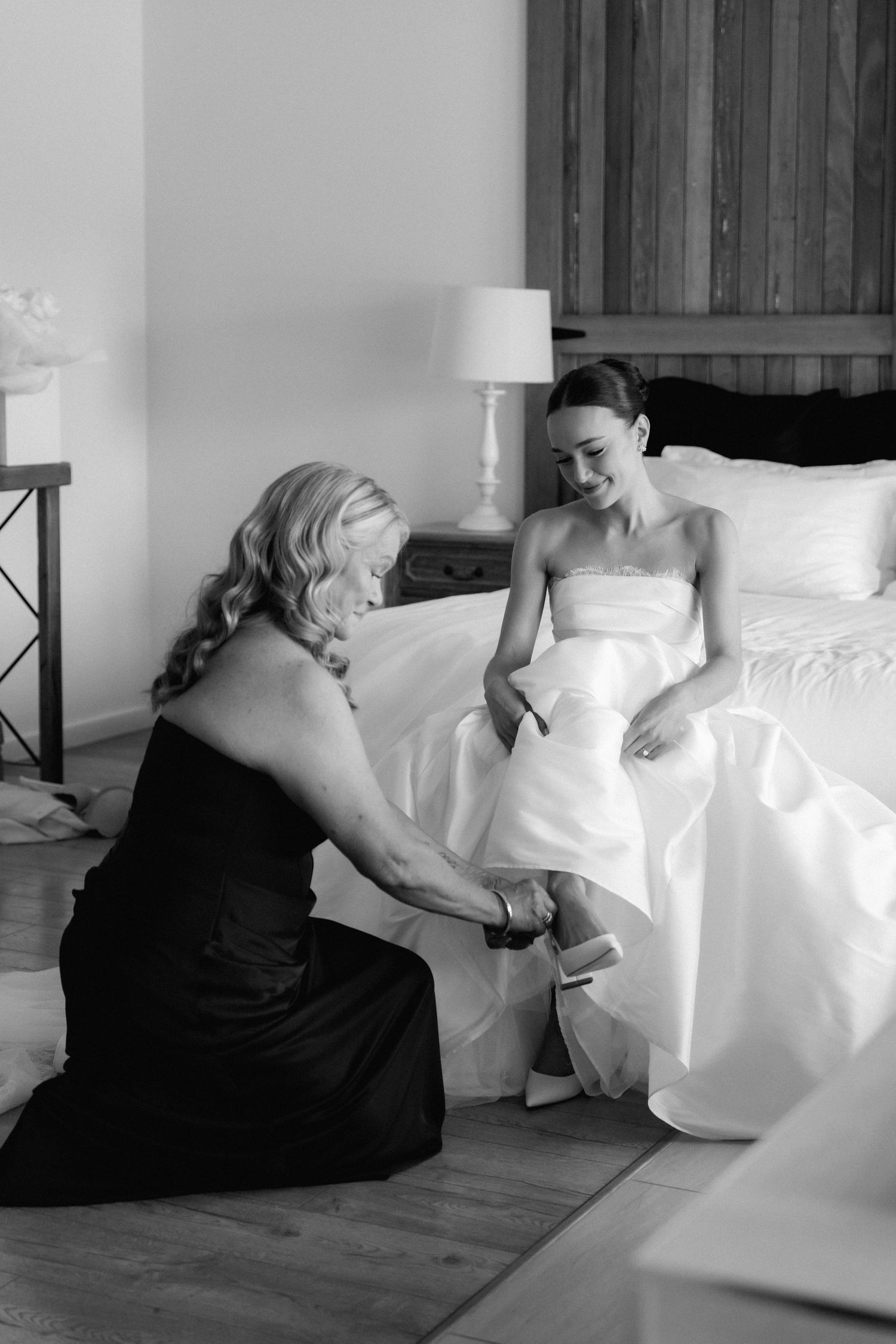 Black and white artistic shots of wedding dress preparation moments.