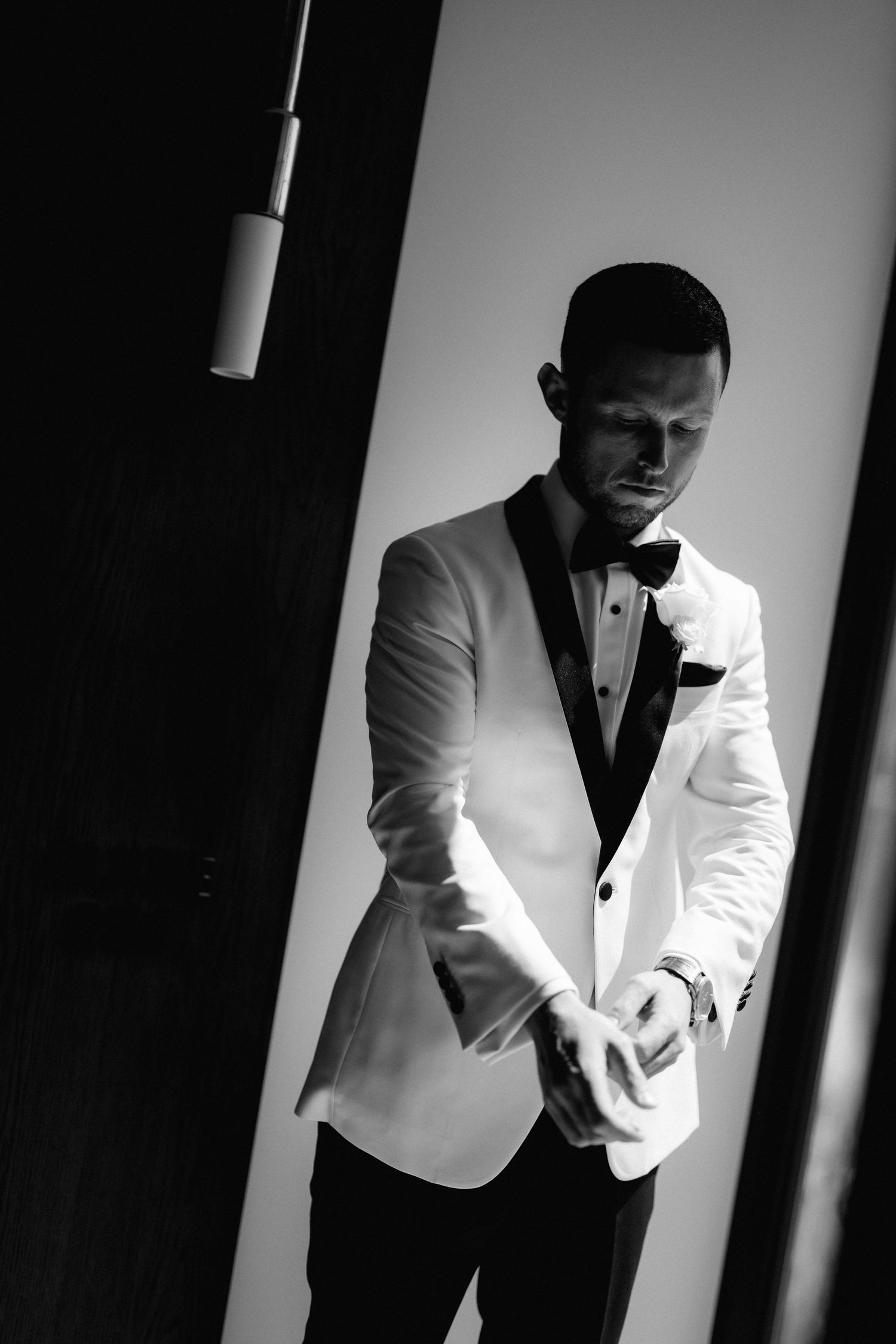 Dramatic black and white portrait series showing a man in a white tuxedo jacket against a dark background.